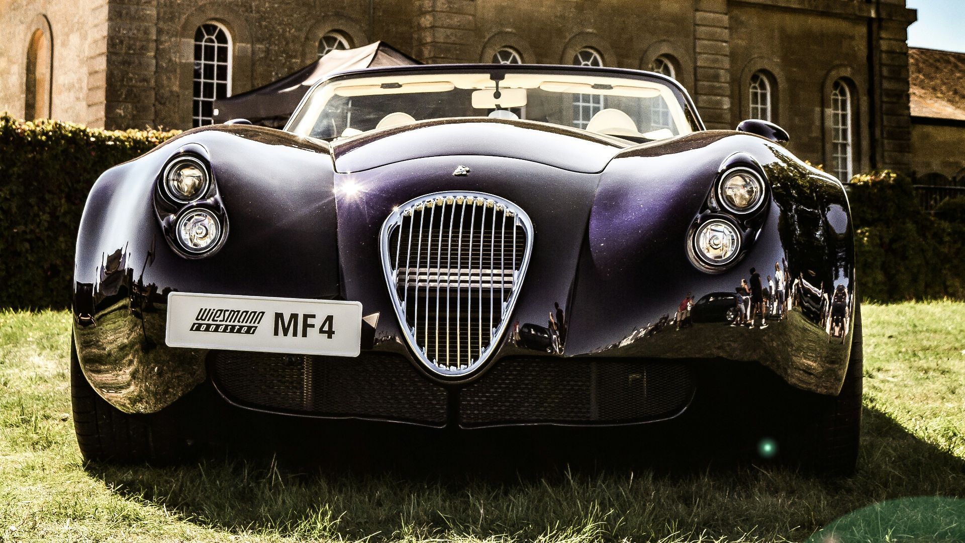 green porsche 911 parked in front of brown concrete building