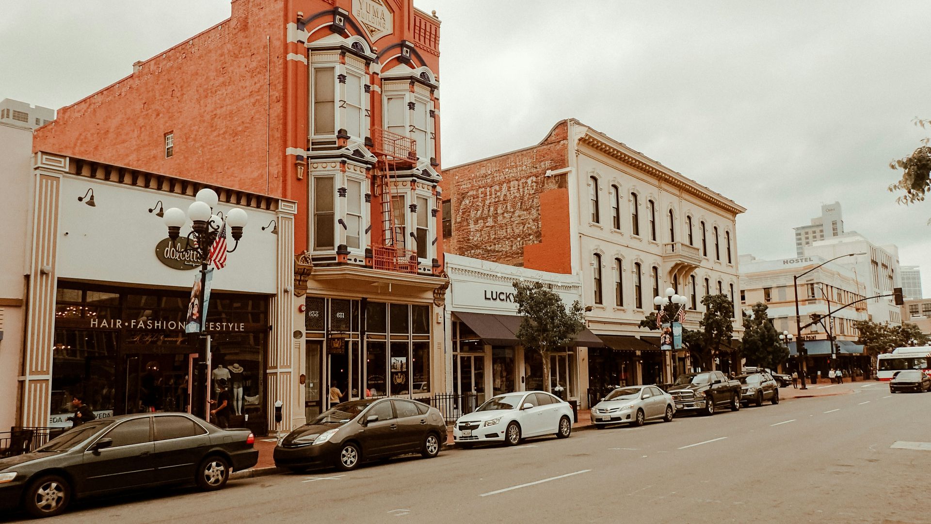 cars parked in front of brown and white concrete building during daytime