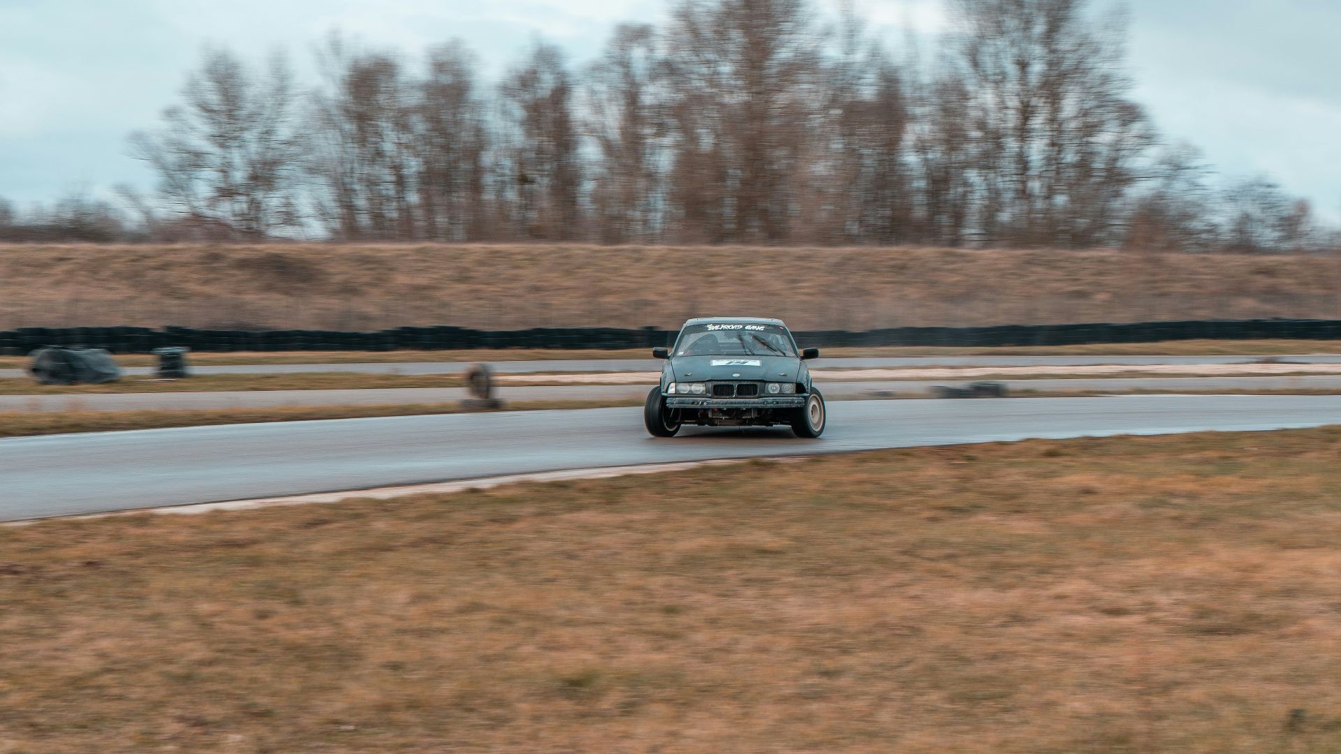 a car driving down a road near a field