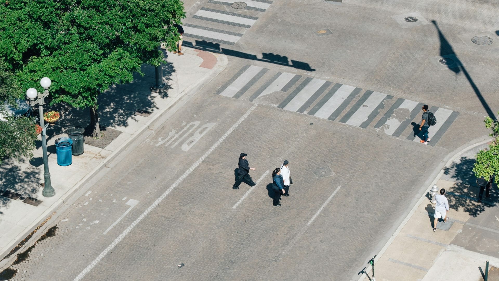 aerial photography of three men crossing road