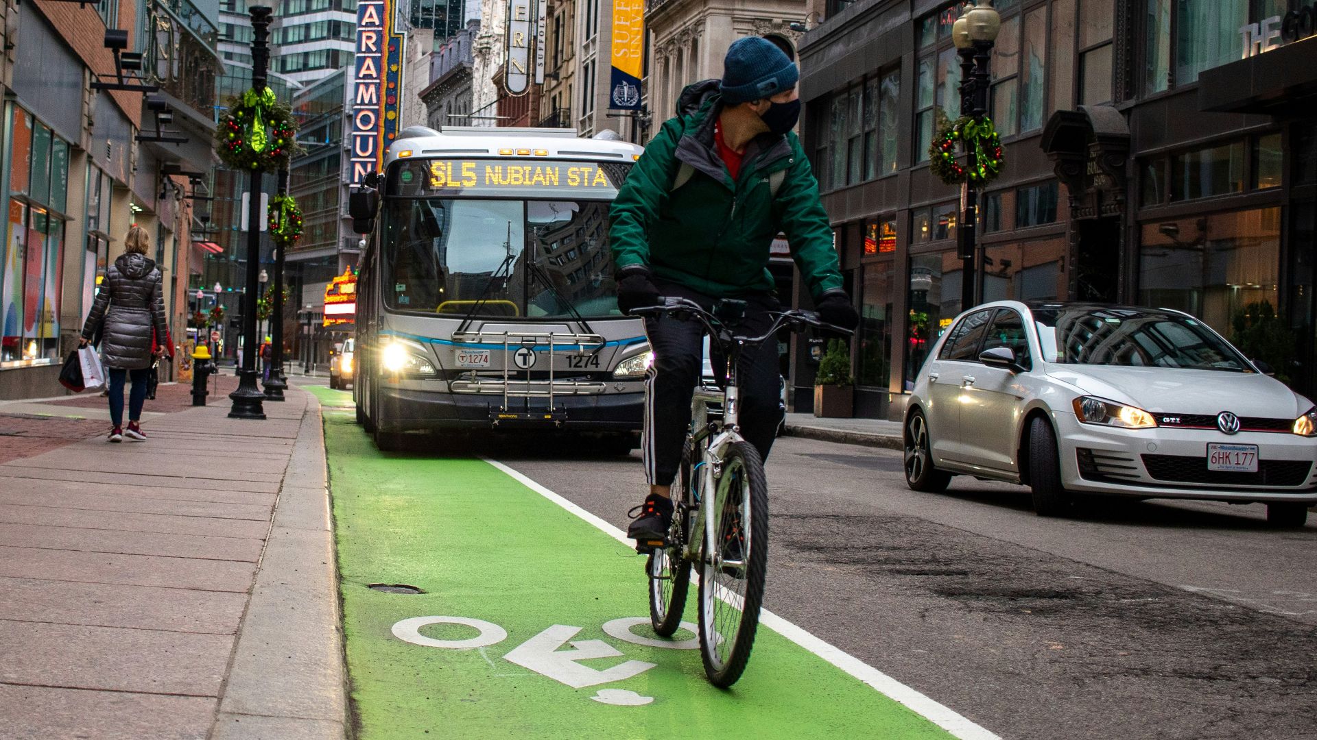 man in black jacket riding bicycle on road during daytime