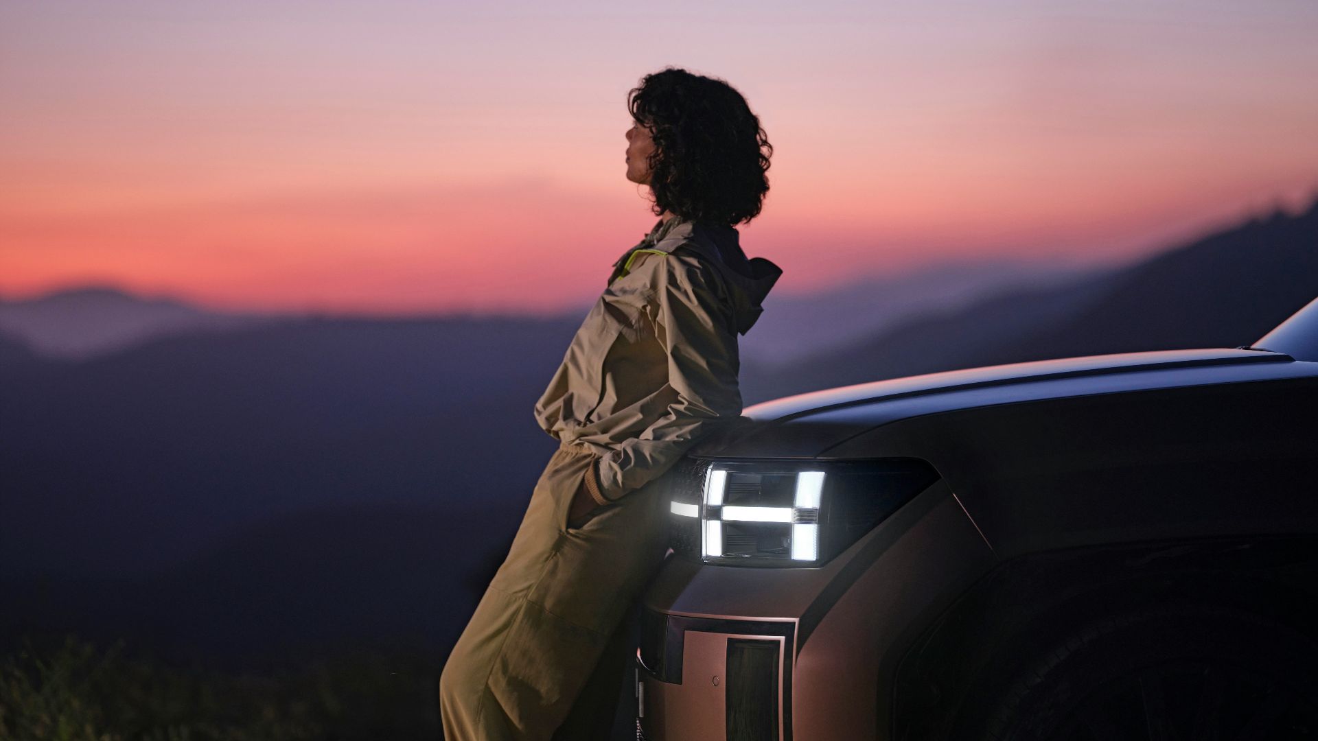 a woman sitting on the hood of a car