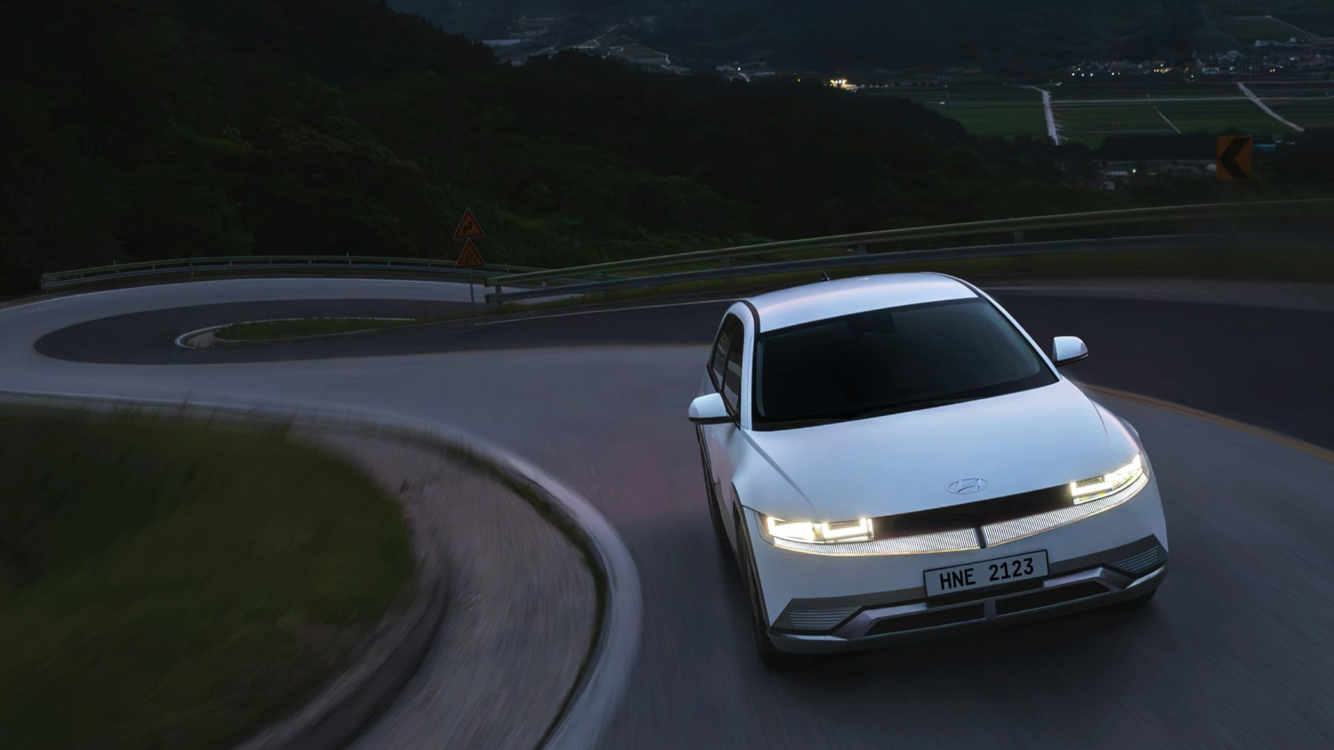 a white car driving down a winding road