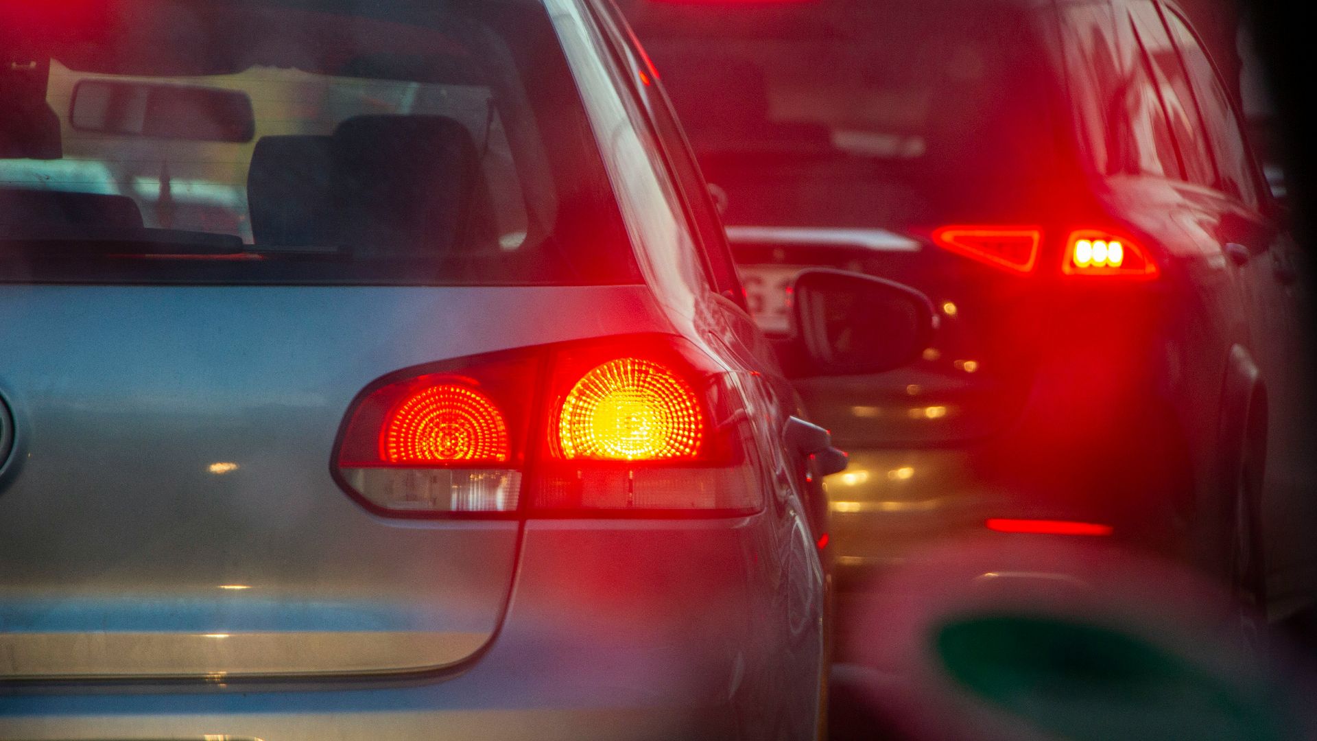 a group of cars driving down a street next to each other