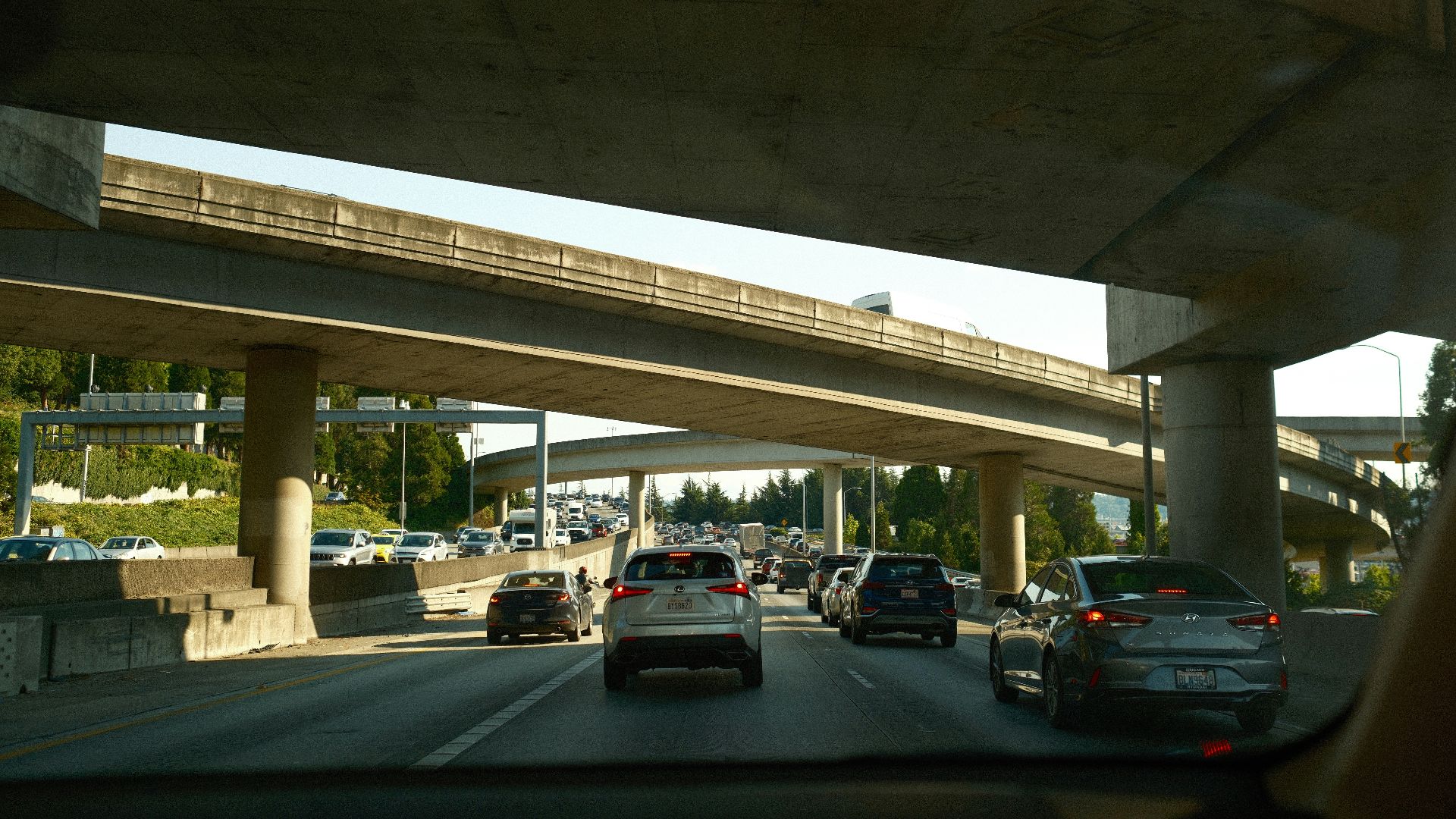 a highway filled with lots of traffic under a bridge