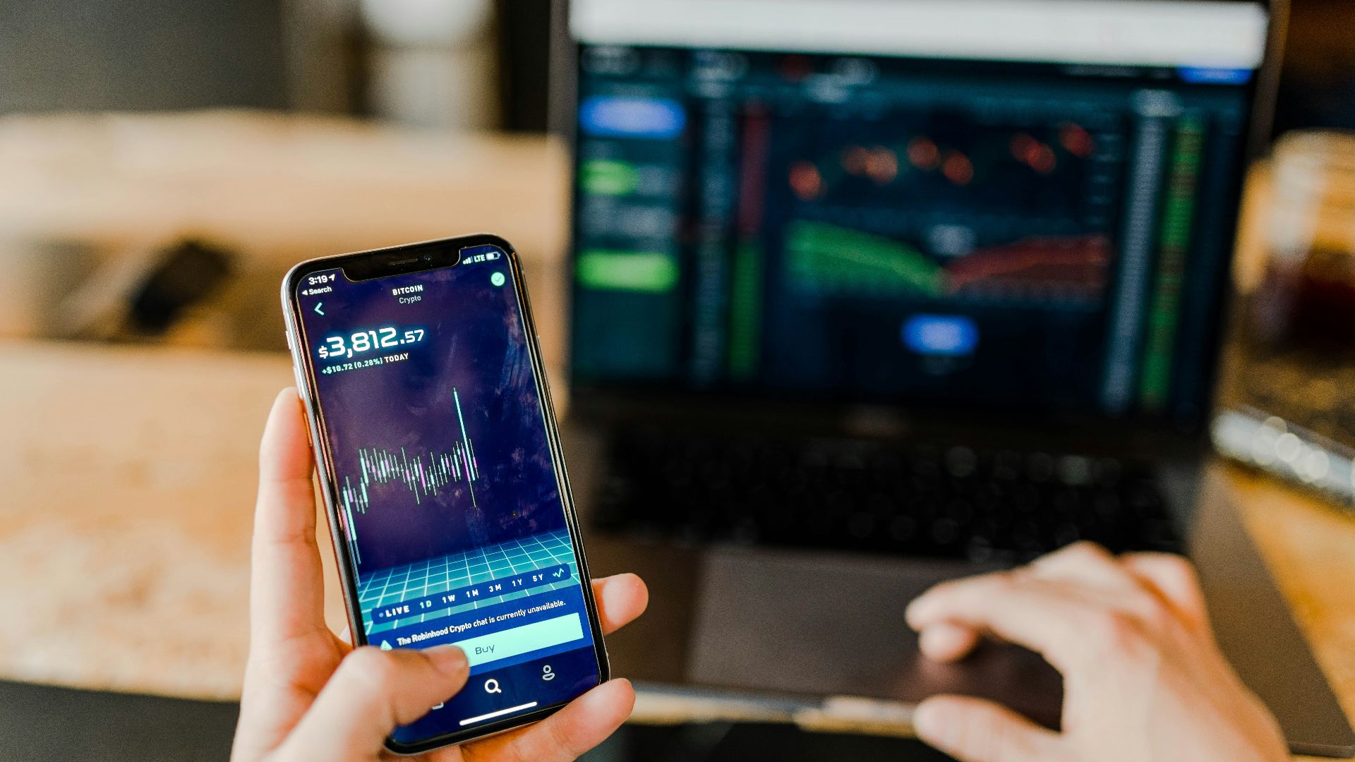 person using phone and laptop computer