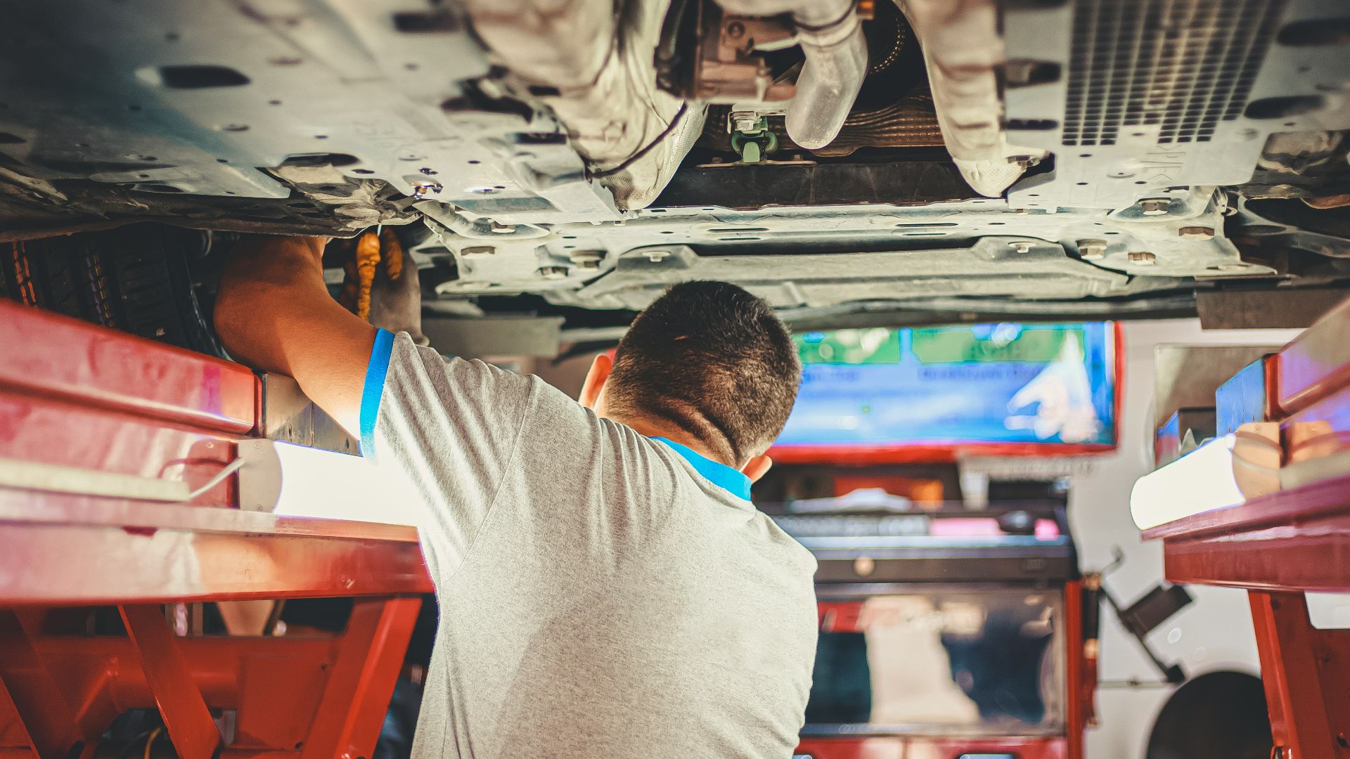 man in gray shirt sitting on red plastic chair