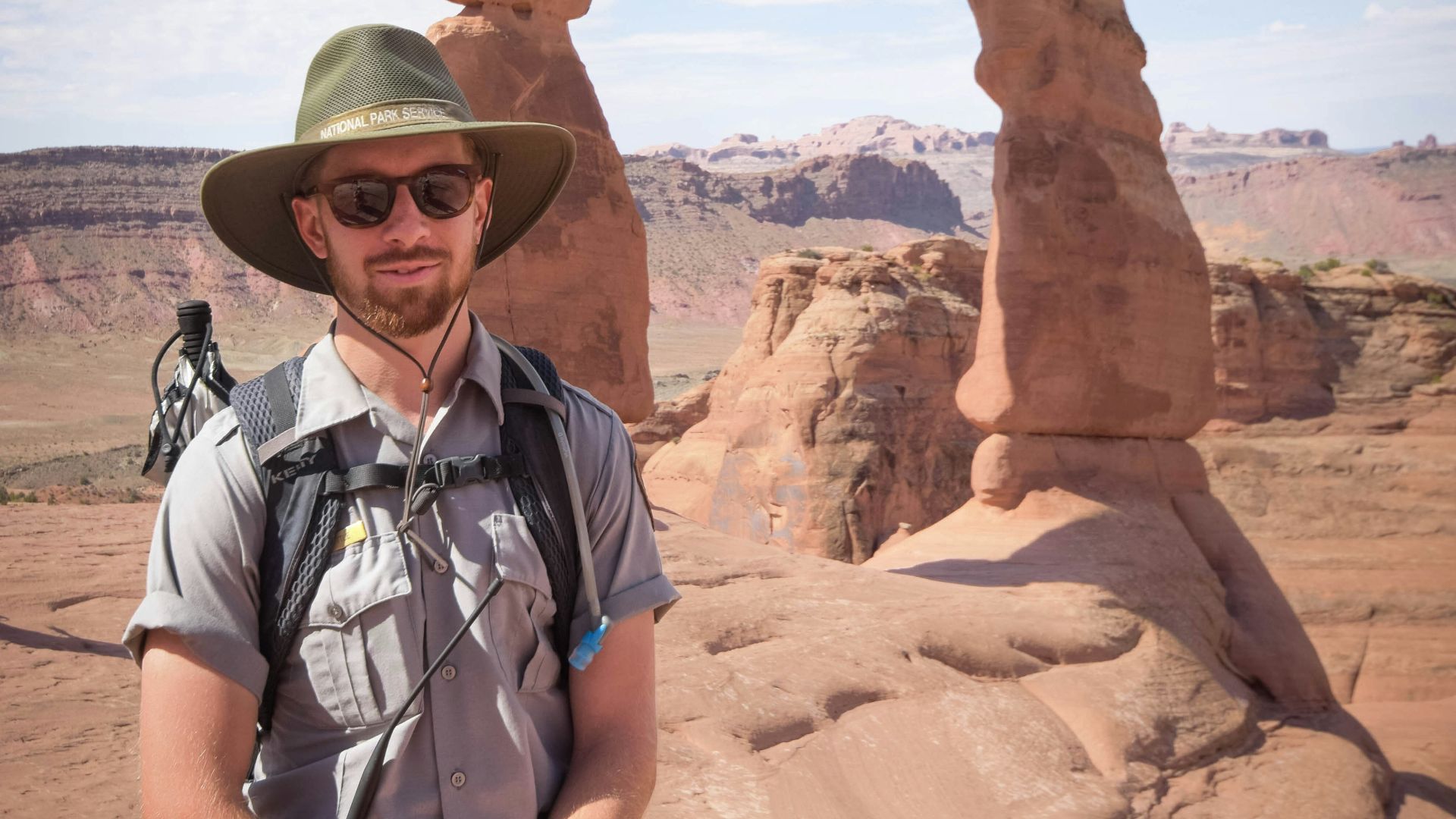 man standing near Delicate Arch