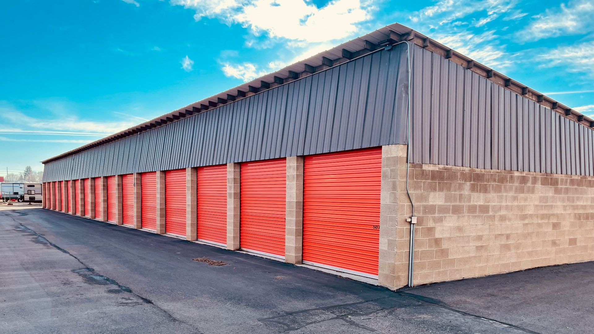 a storage building with red doors and a sky background