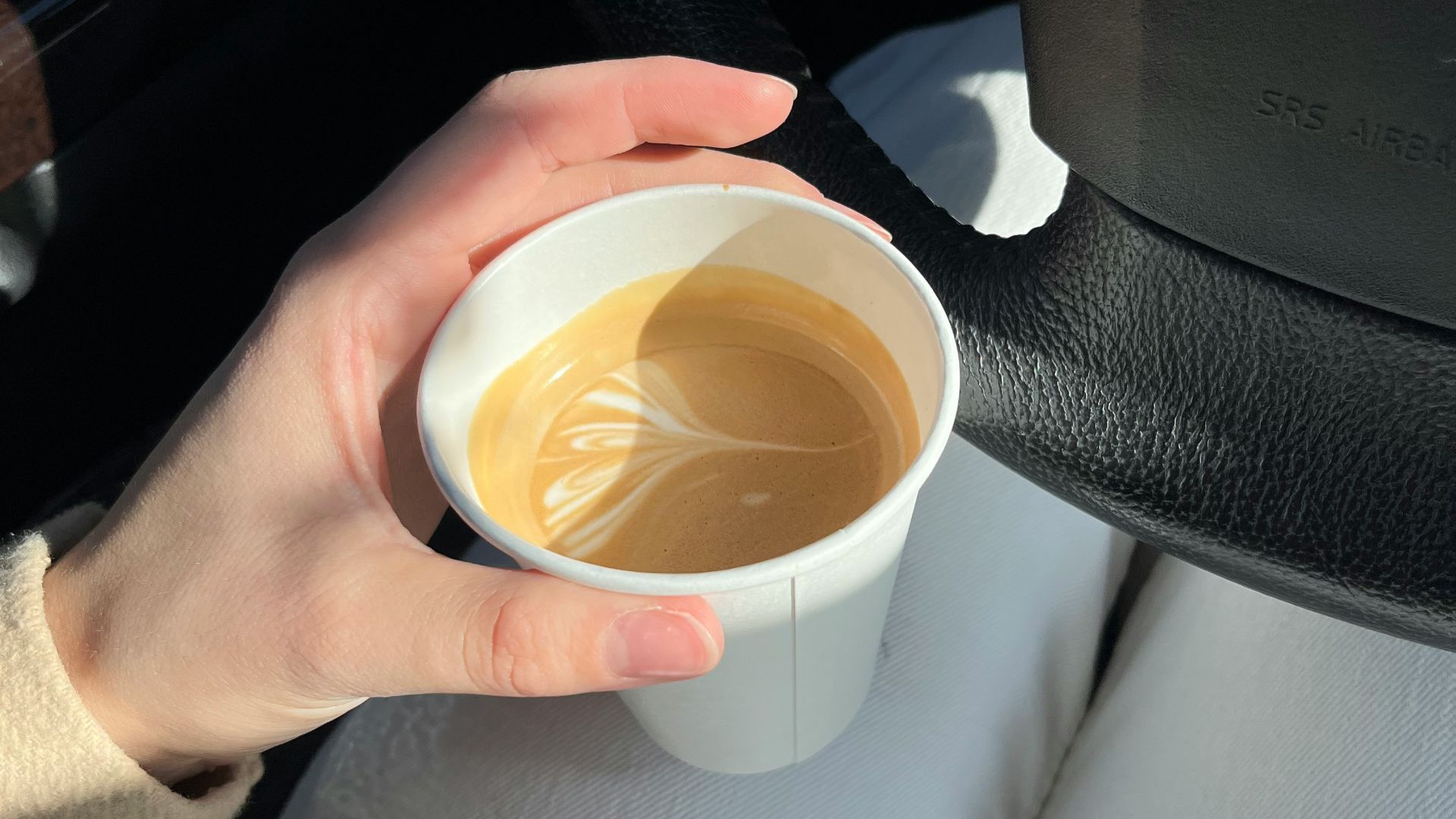 a person holding a cup of coffee in their hand