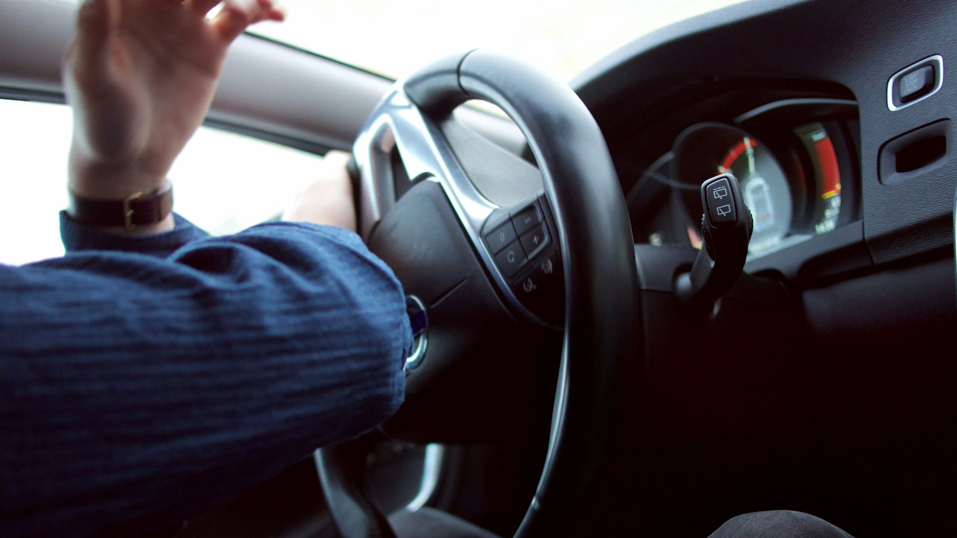man holding black steering wheel