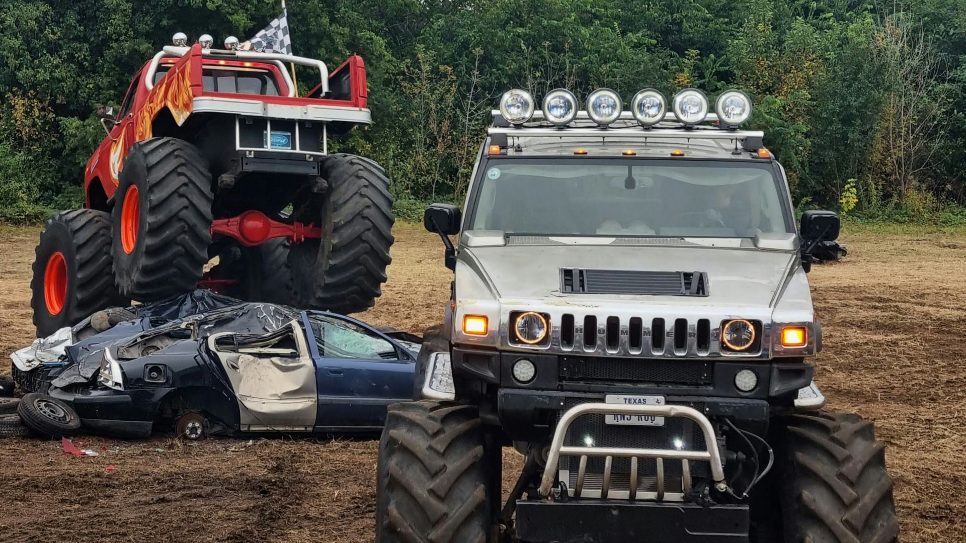 a car that is sitting in the dirt next to a monster truck