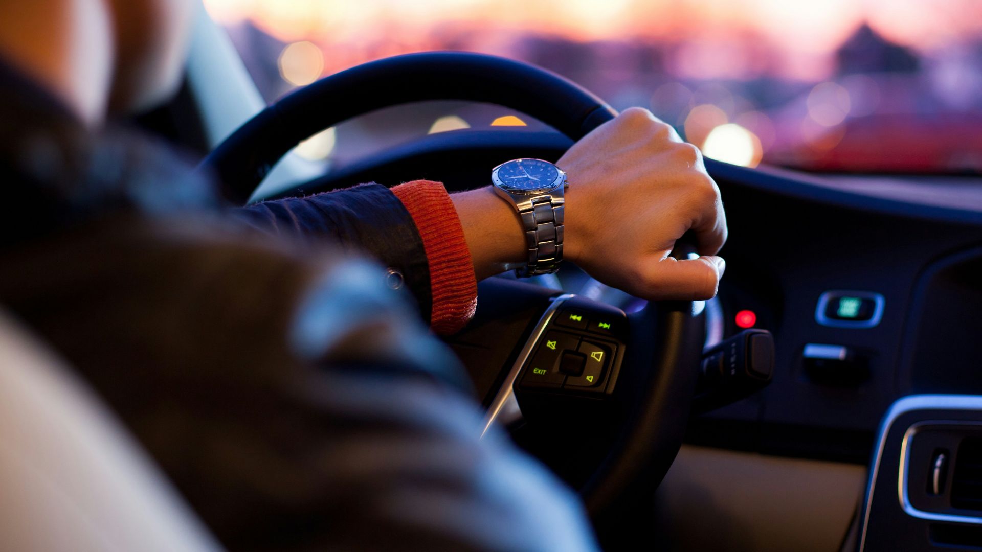 man driving a car wearing wrist watch