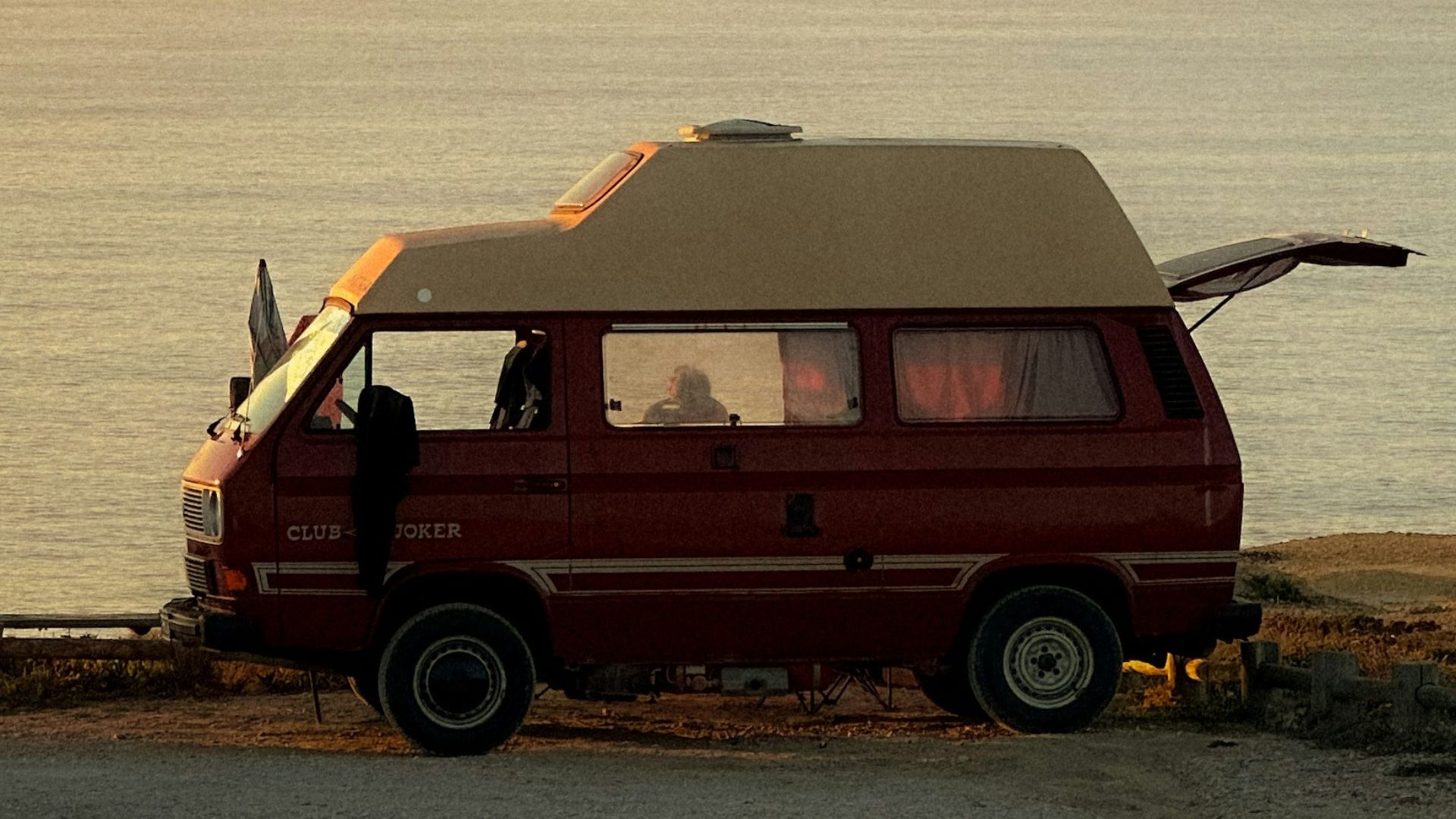 a van parked on the side of a road next to the ocean