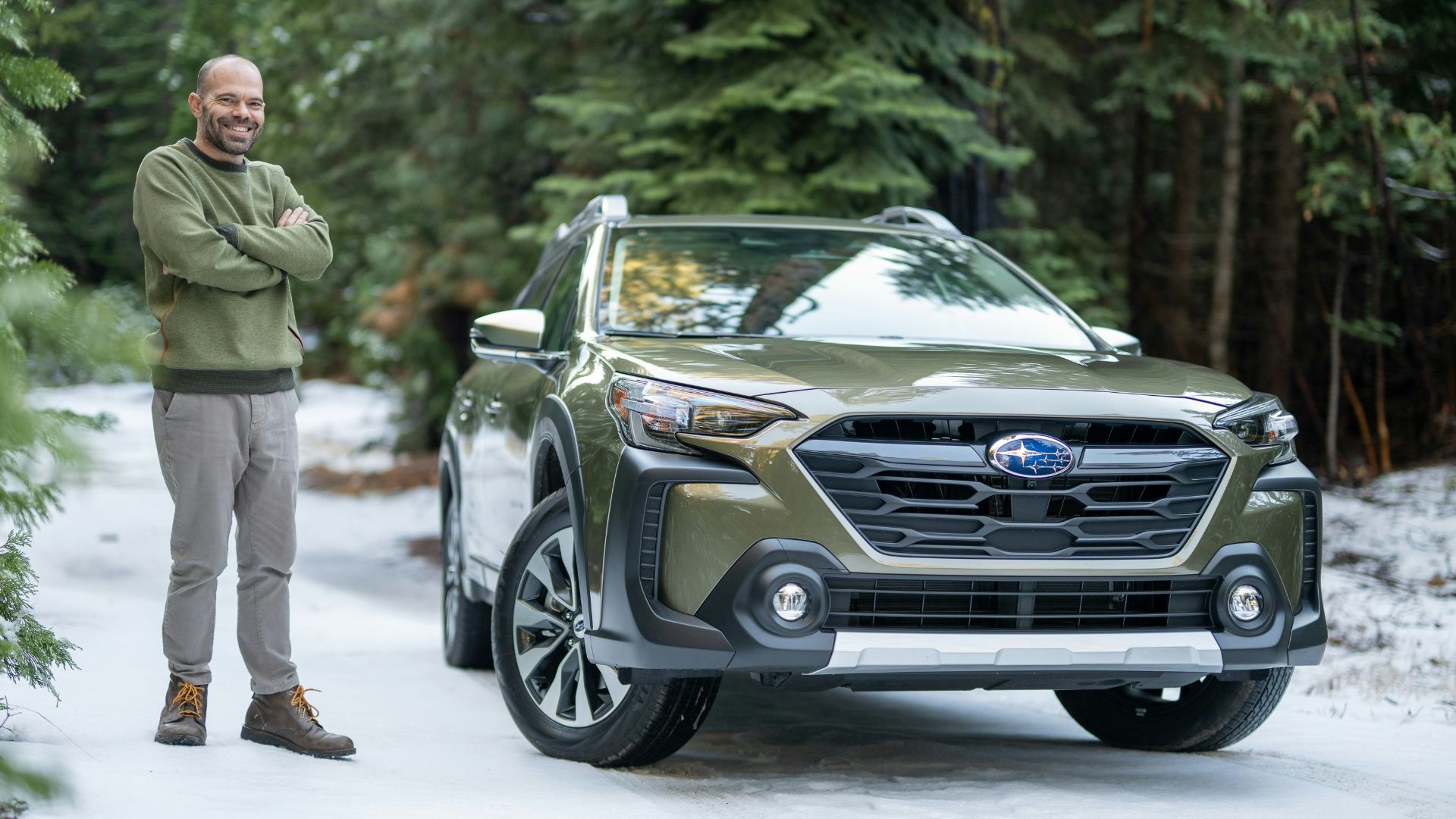 A man standing next to a car in the snow