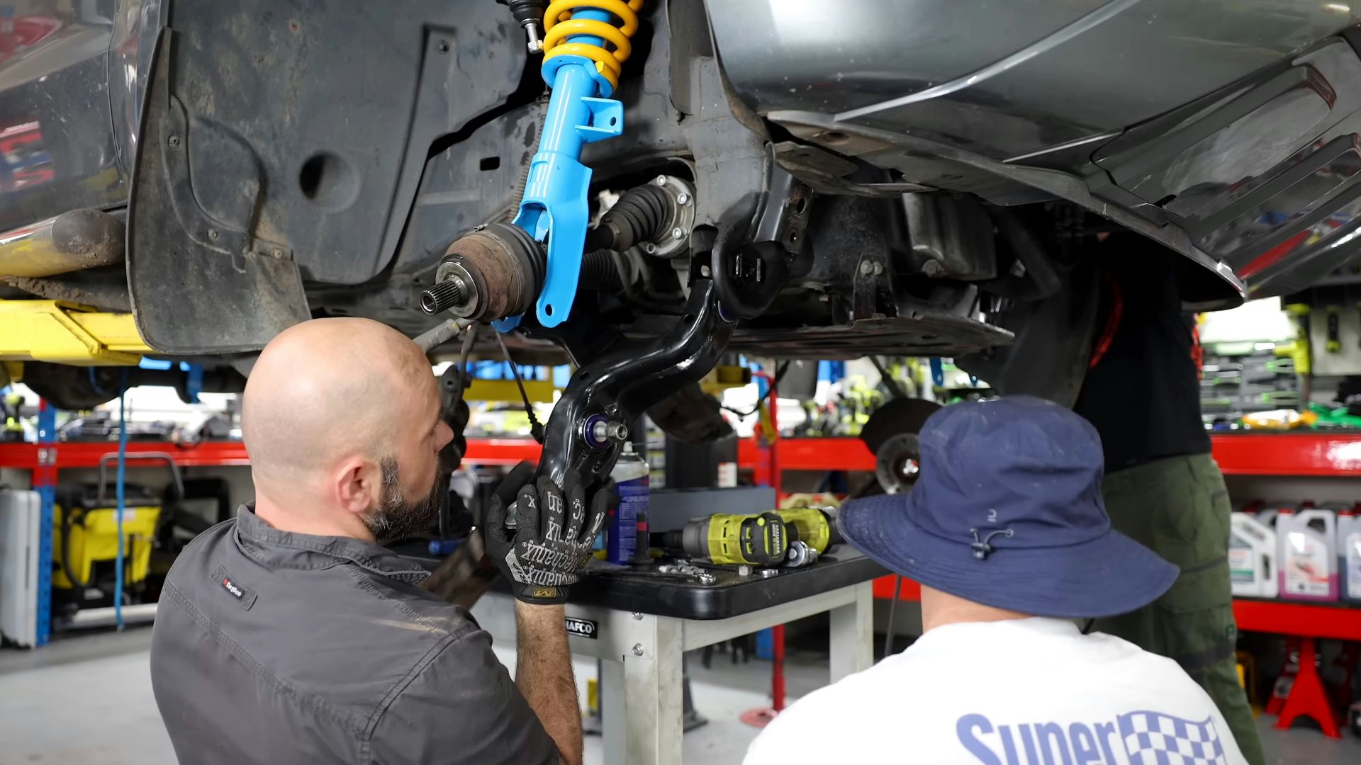 Two men working on a car in a garage