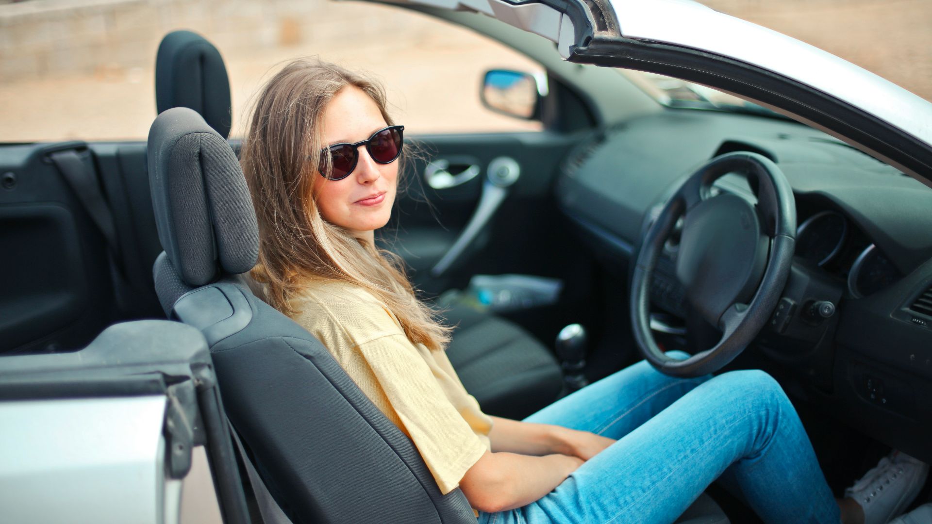 smiling woman sitting on black and white vehicle