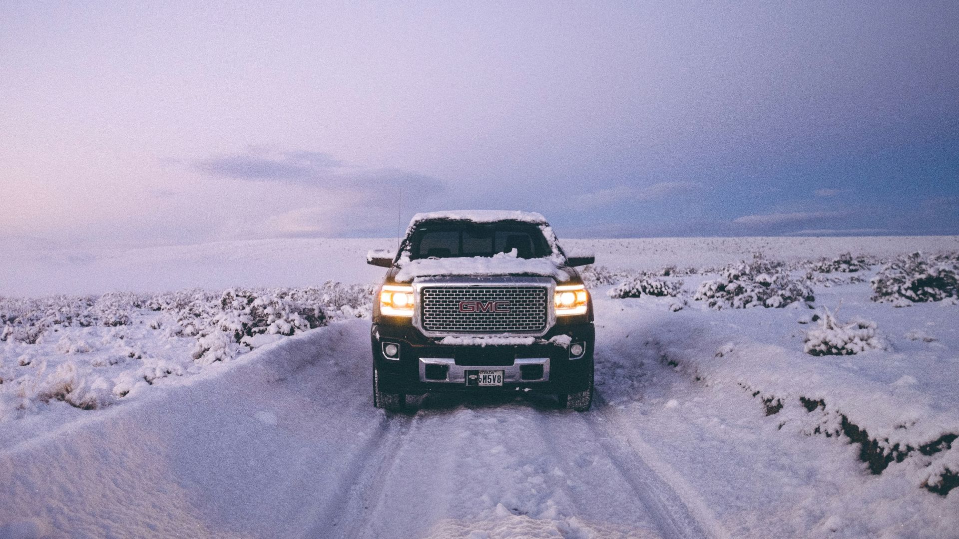 black GMC Sierra Denali on snow covered road