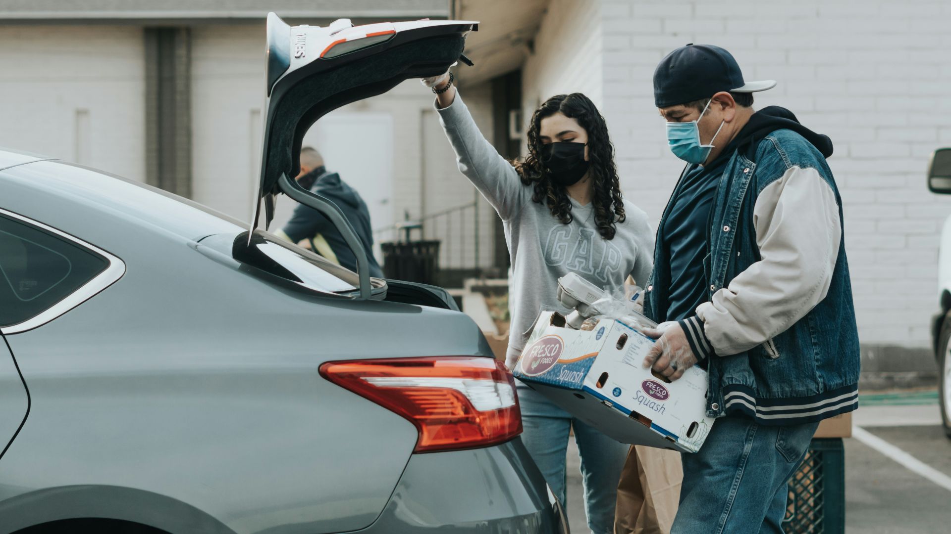 man in blue jacket standing beside woman in white jacket