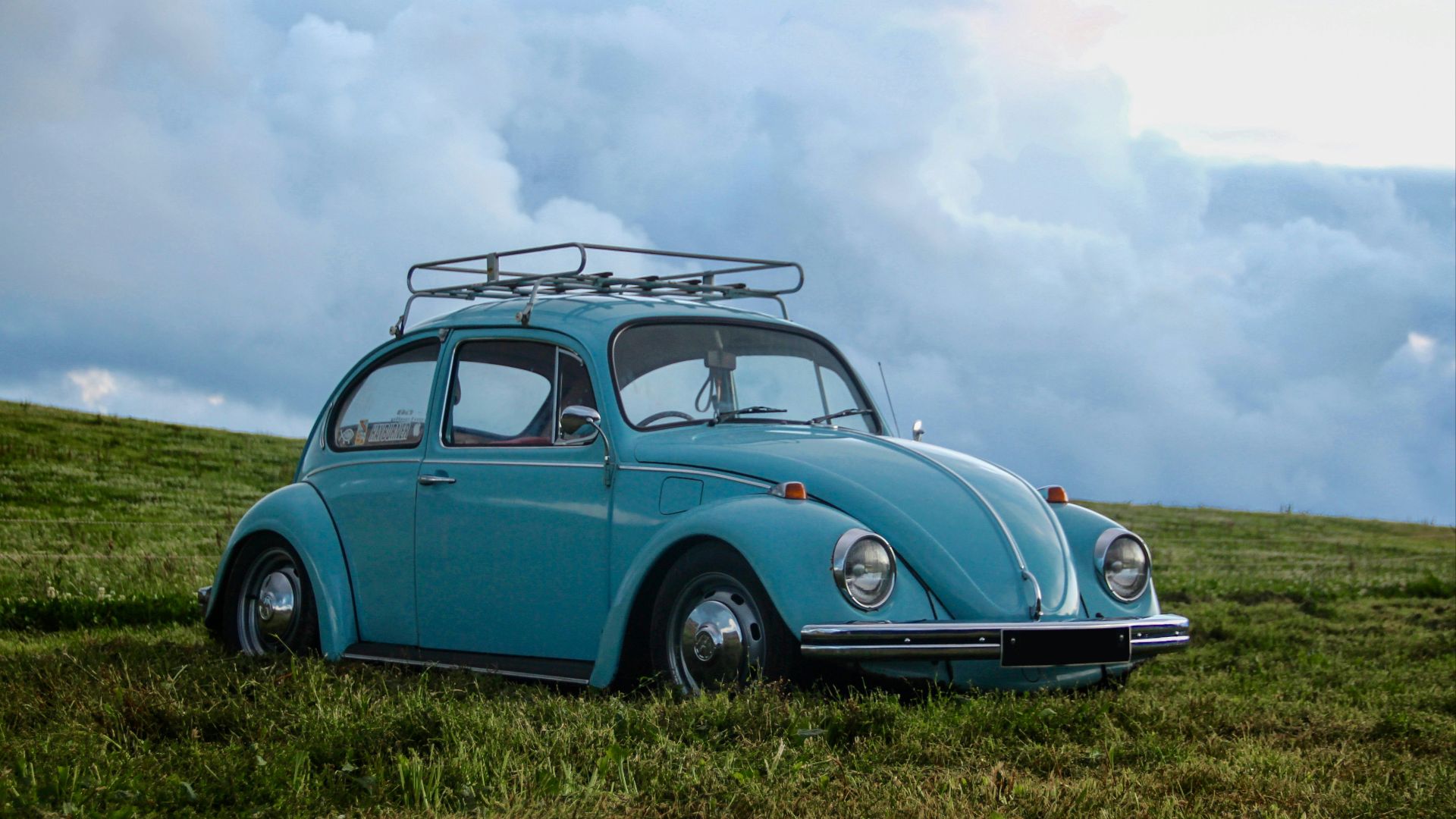 blue Volkswagen Beetle on grass field