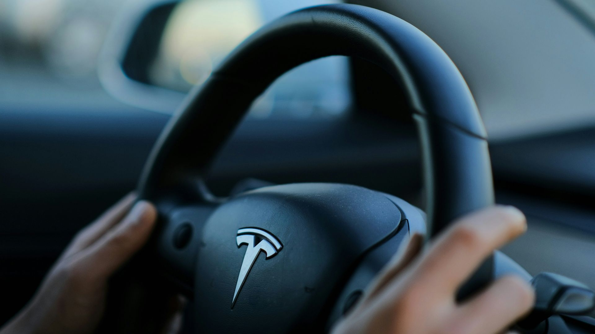 A person holding a steering wheel while driving a car