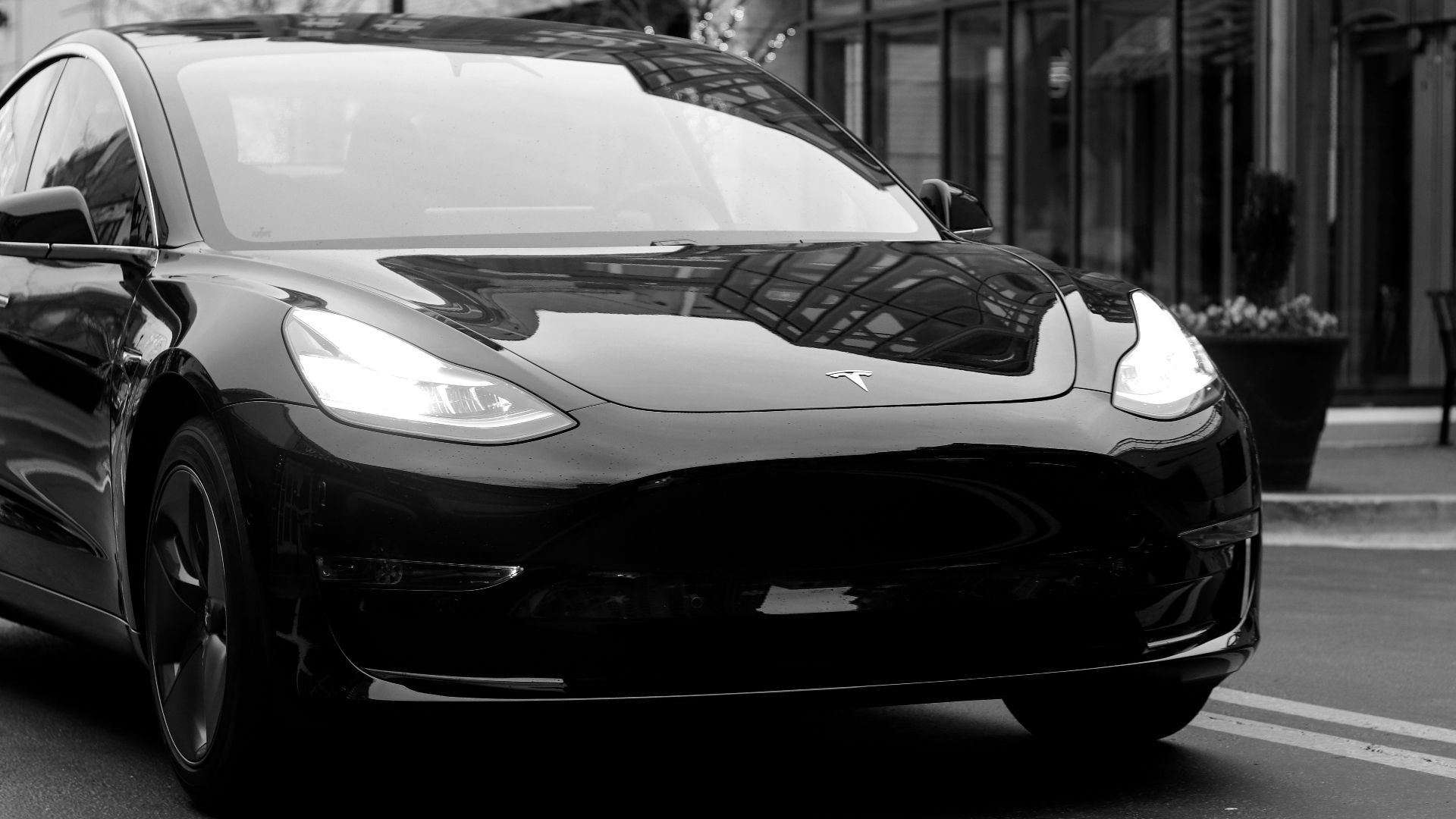 grayscale photography of Grand tourer parking near road