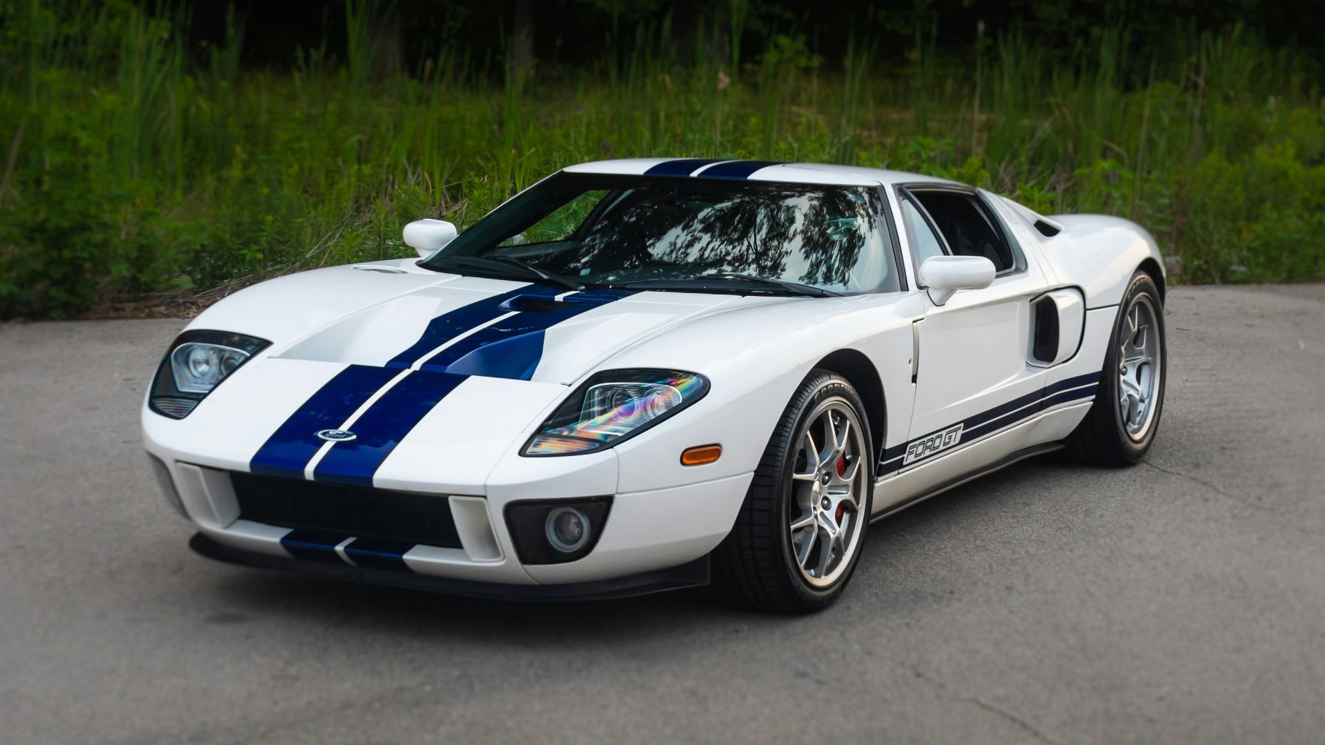 a white and blue sports car parked in a parking lot