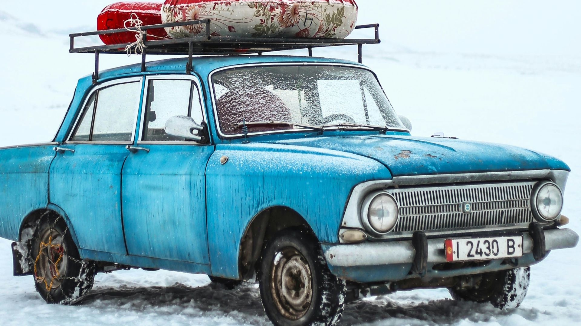 blue sedan on snow ground