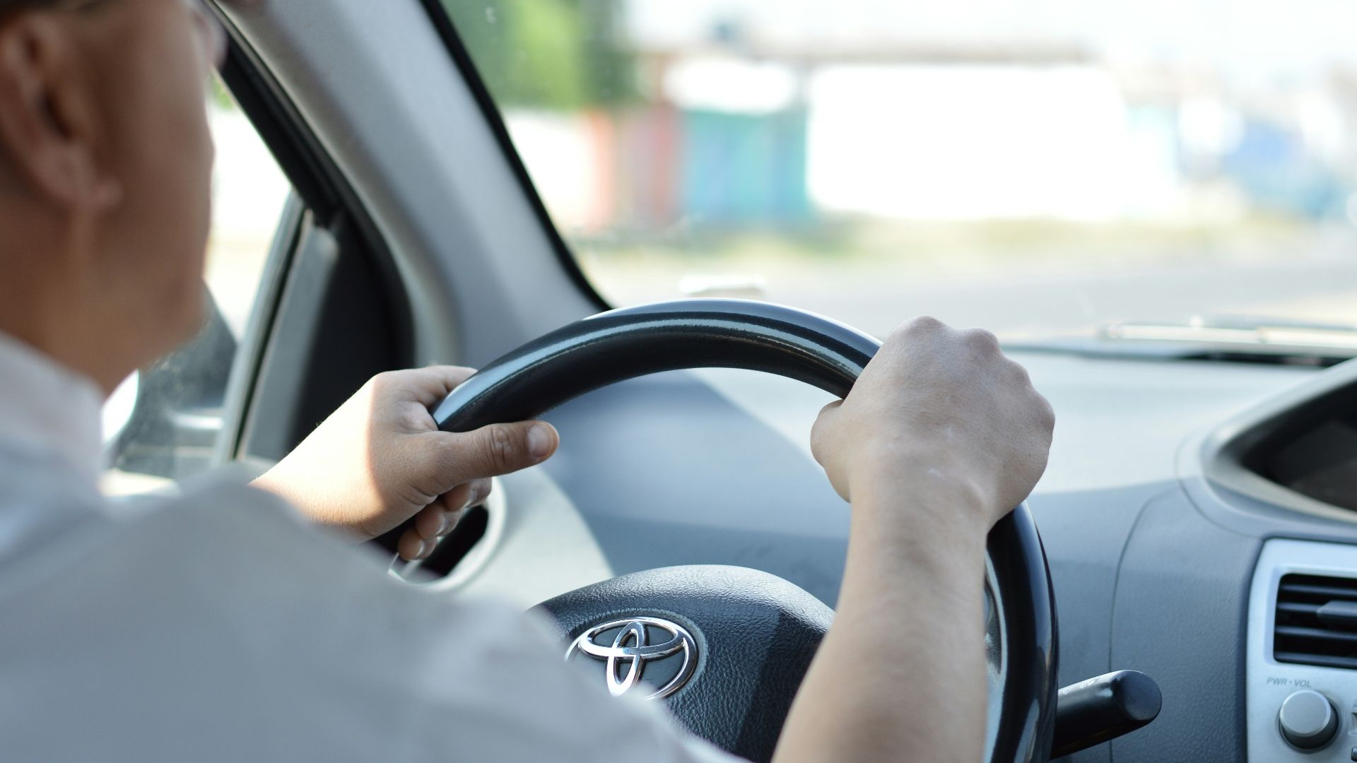 person in white long sleeve shirt driving car