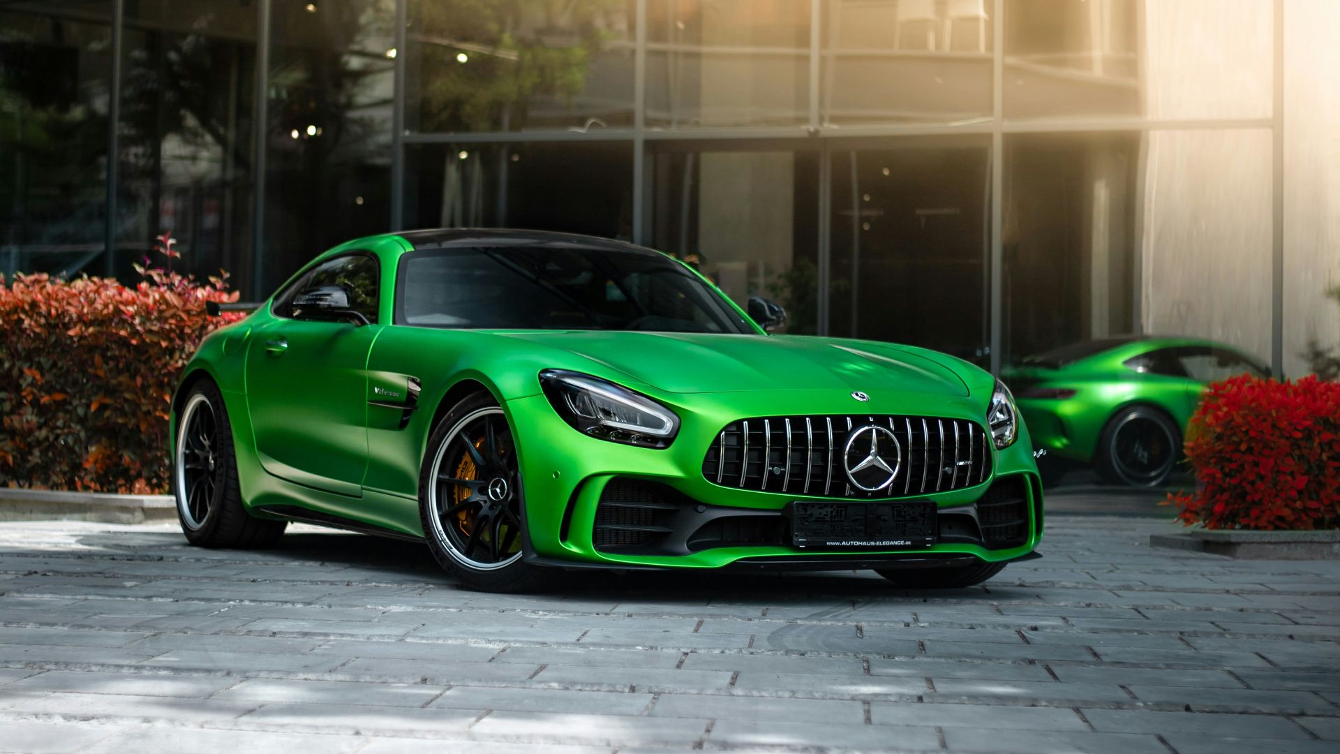 a green sports car parked in front of a building