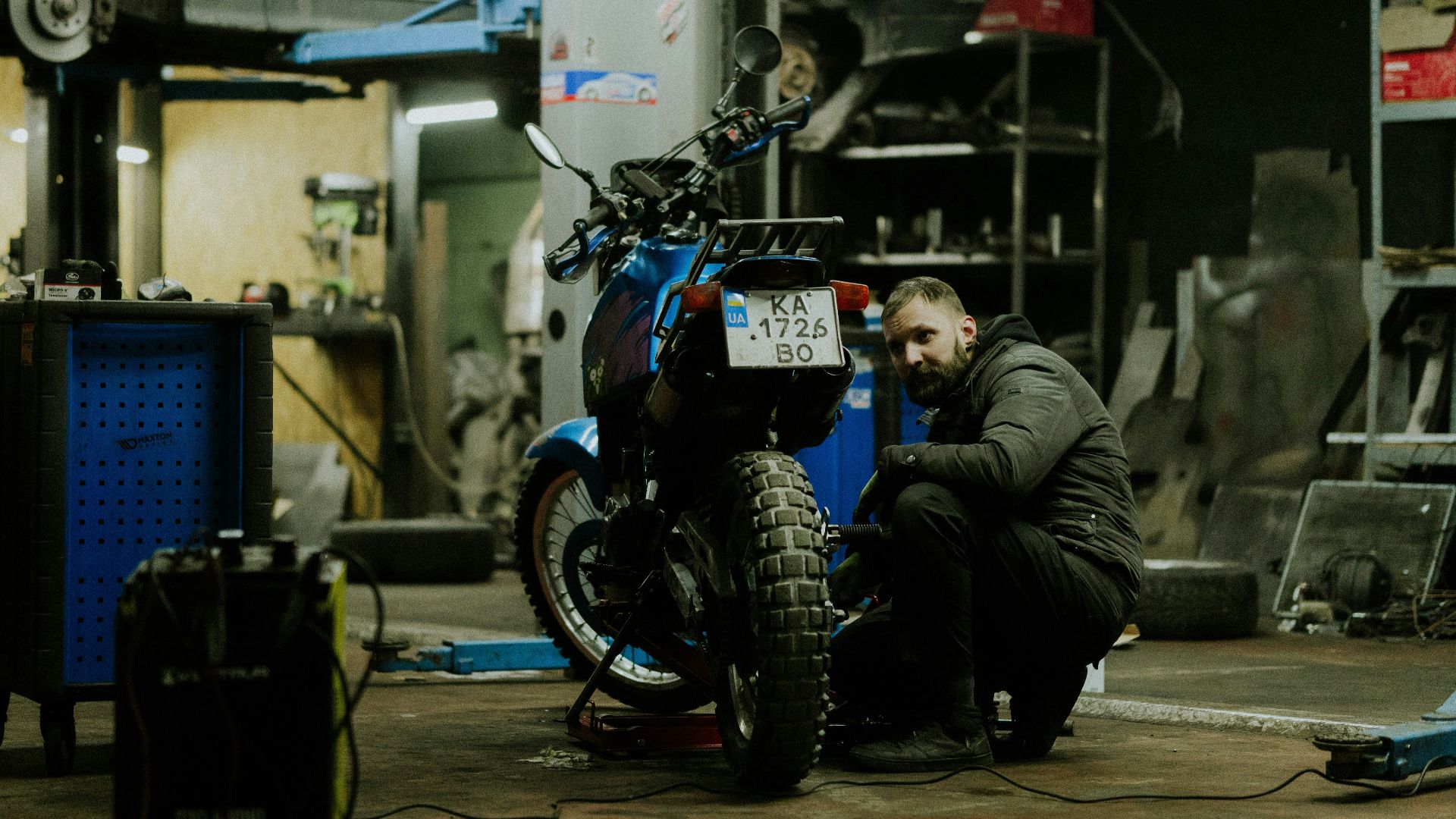 a man working on a motorcycle in a garage