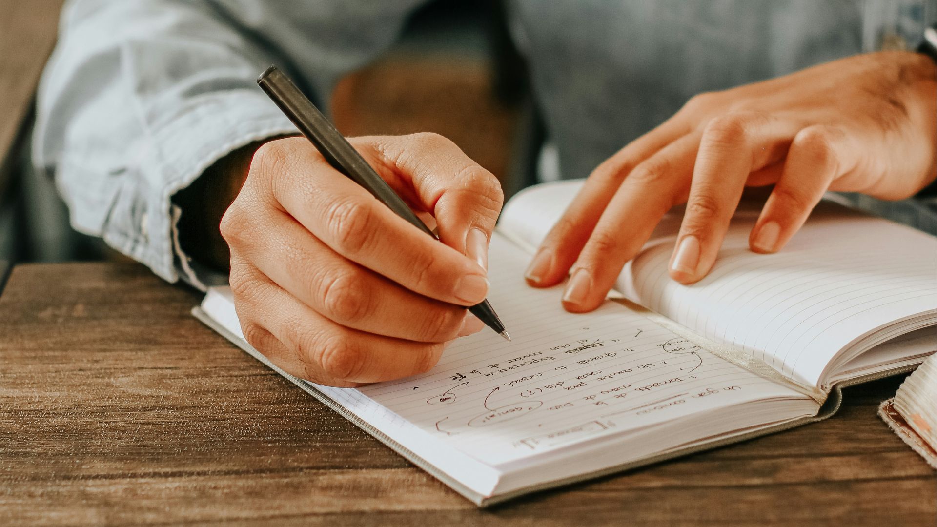 person in gray dress shirt writing on white paper