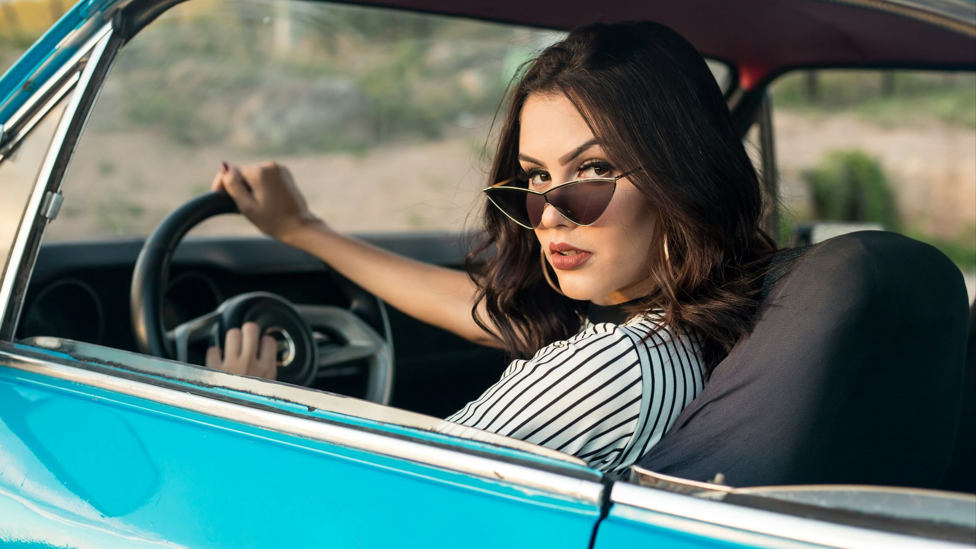 selective focus photography of woman driving blue car