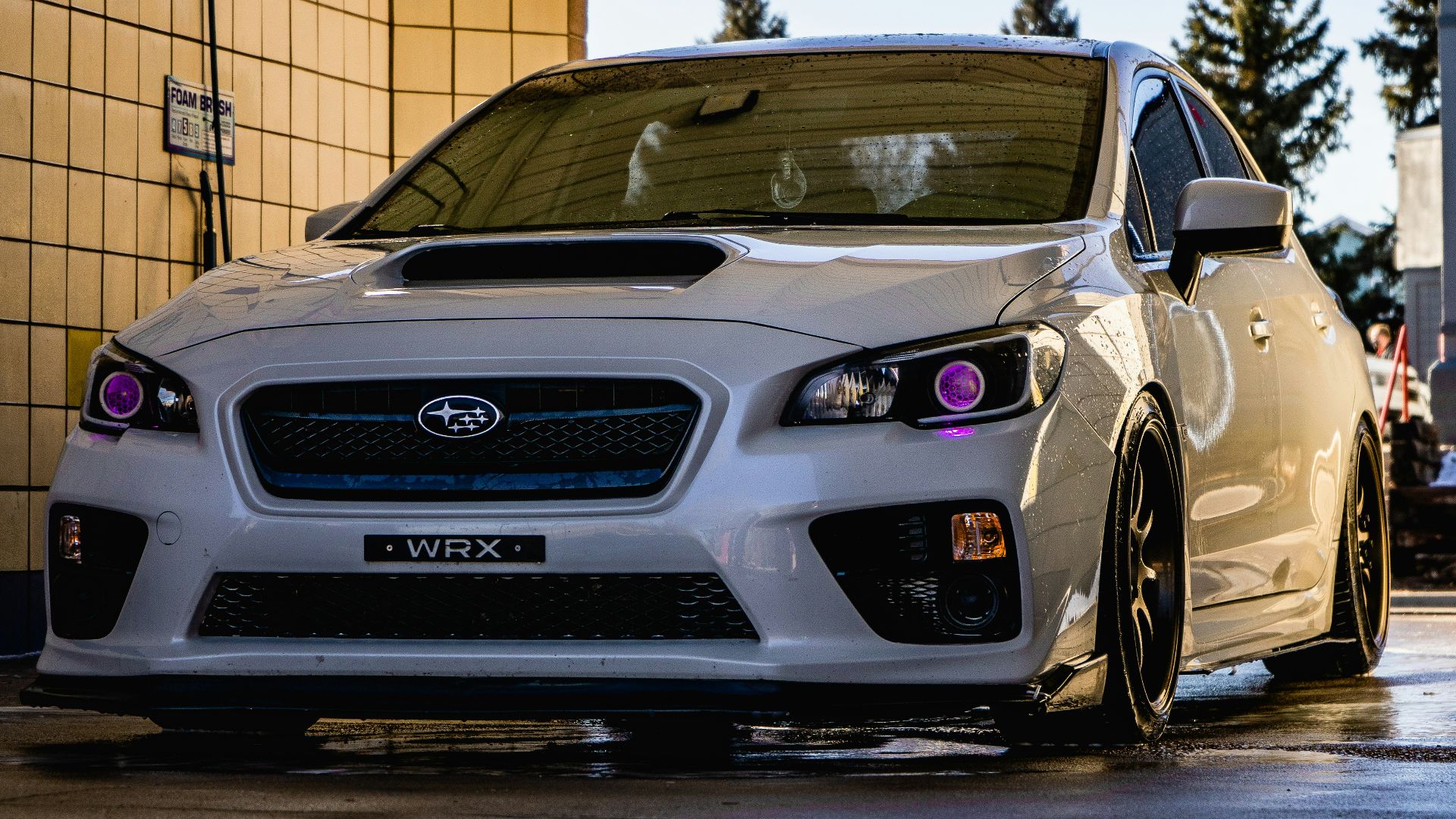 white honda car parked beside brown brick wall