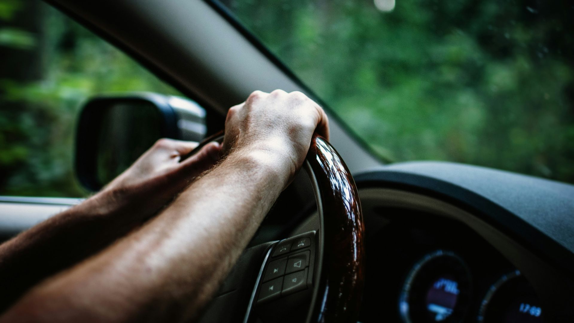 person holding car steering wheel