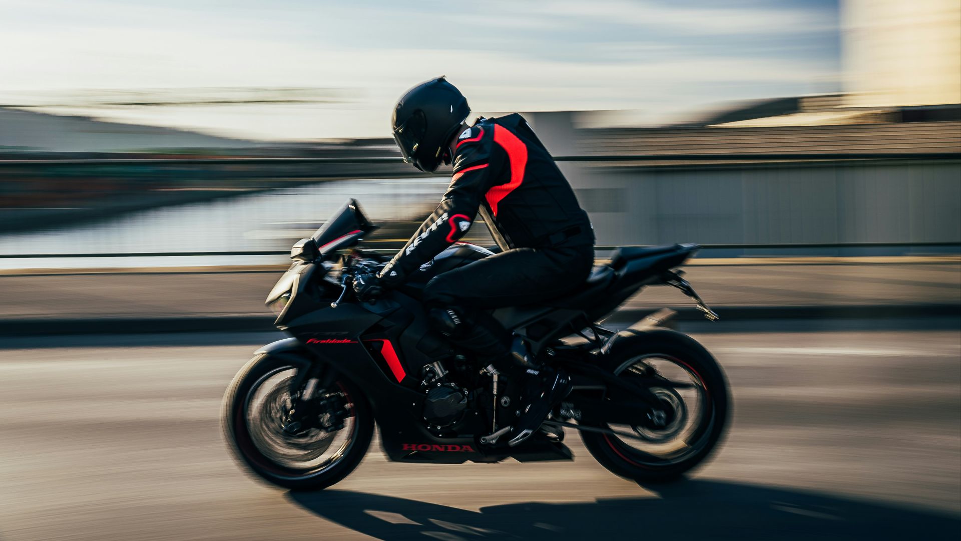 man in black helmet riding black sports bike on road during daytime