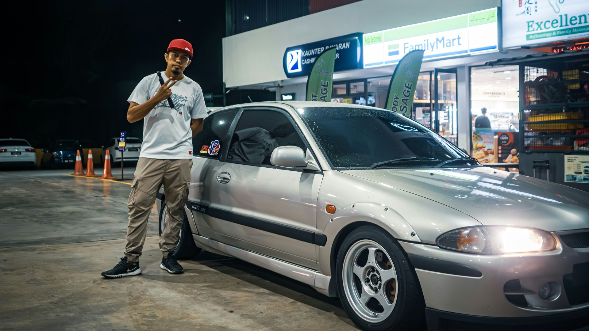 A man standing next to a silver car