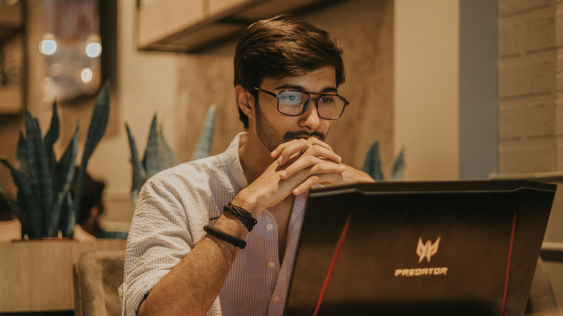 a man sitting at a table using a laptop computer
