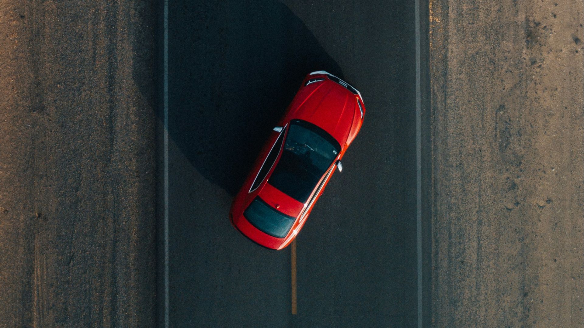 two red vehicles on road during daytime
