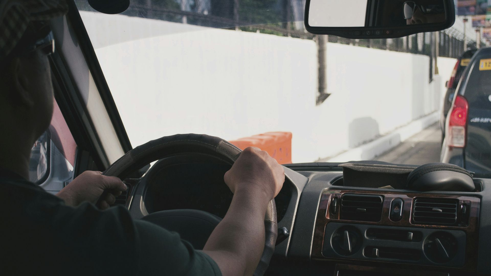 person driving vehicle on road near vehicle at daytime