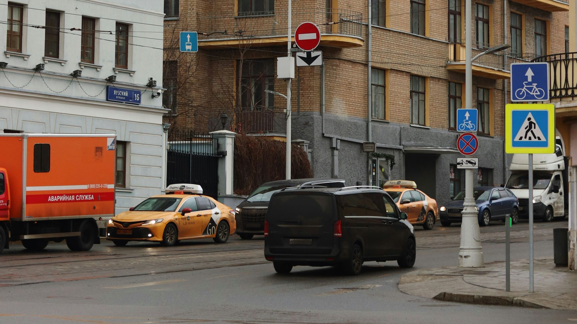a city street filled with lots of traffic next to tall buildings