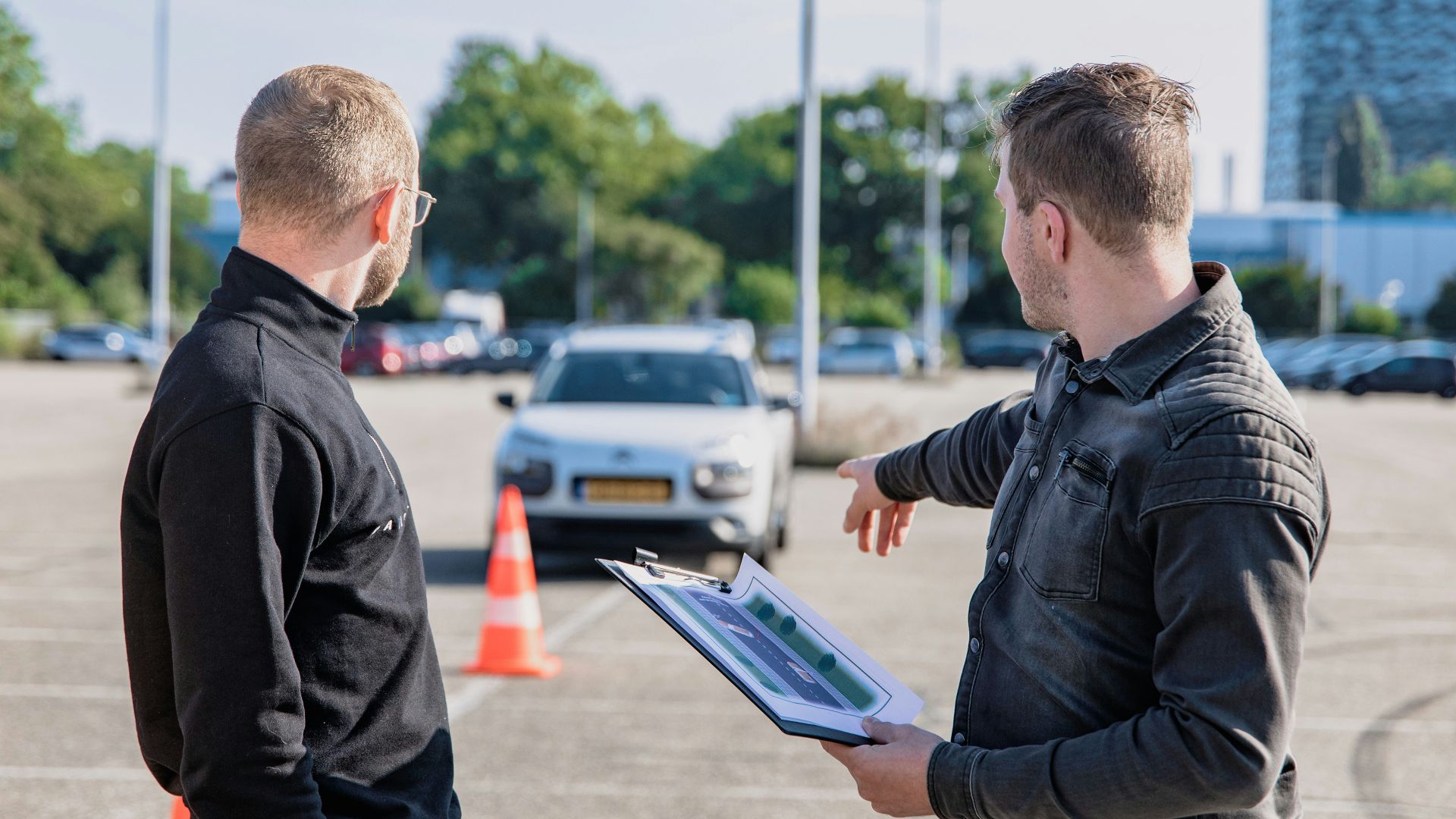 man in black jacket holding blue tablet computer