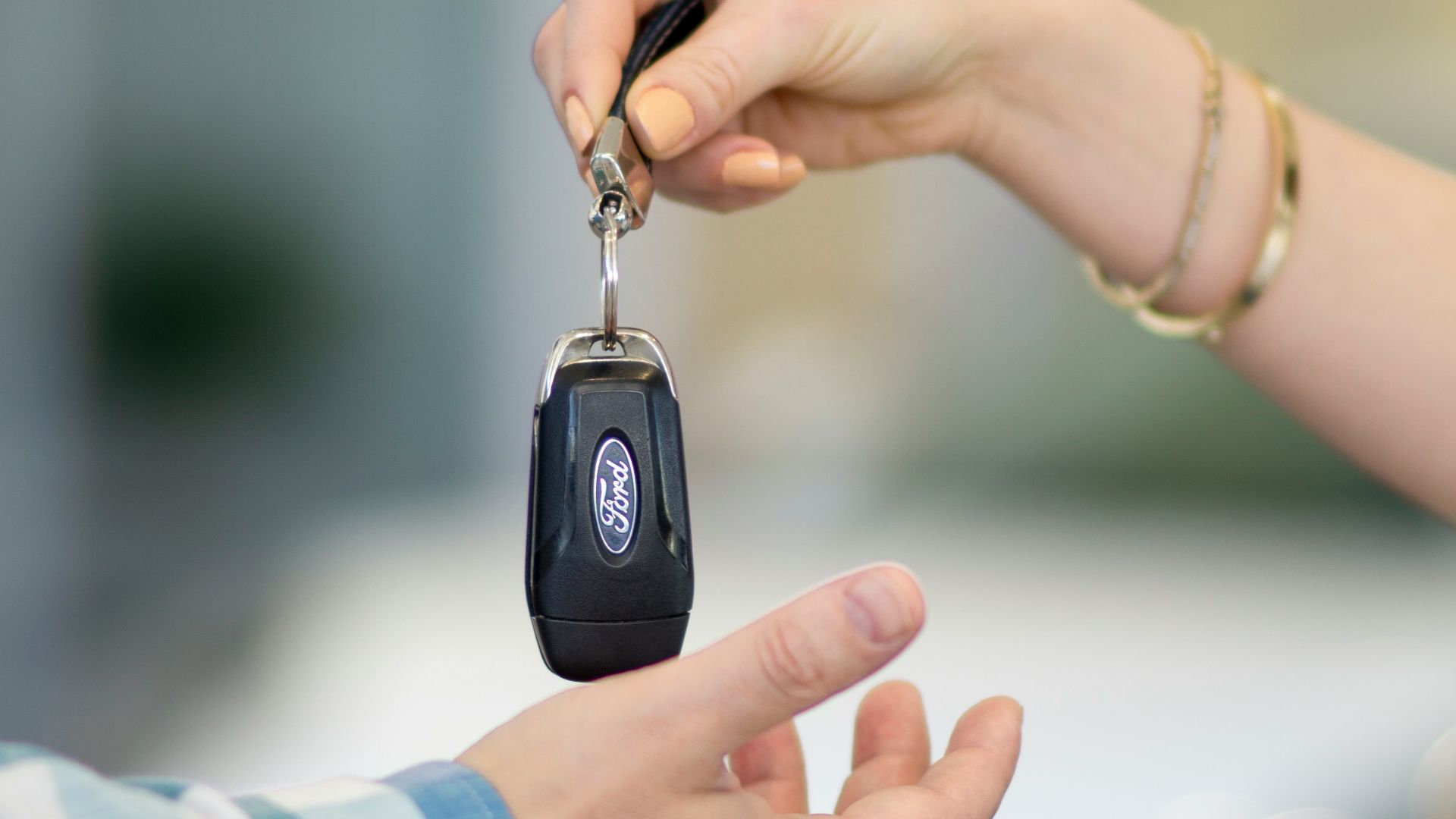 A person handing a car key to another person