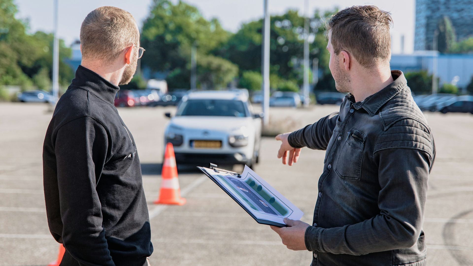 man in black jacket holding blue tablet computer