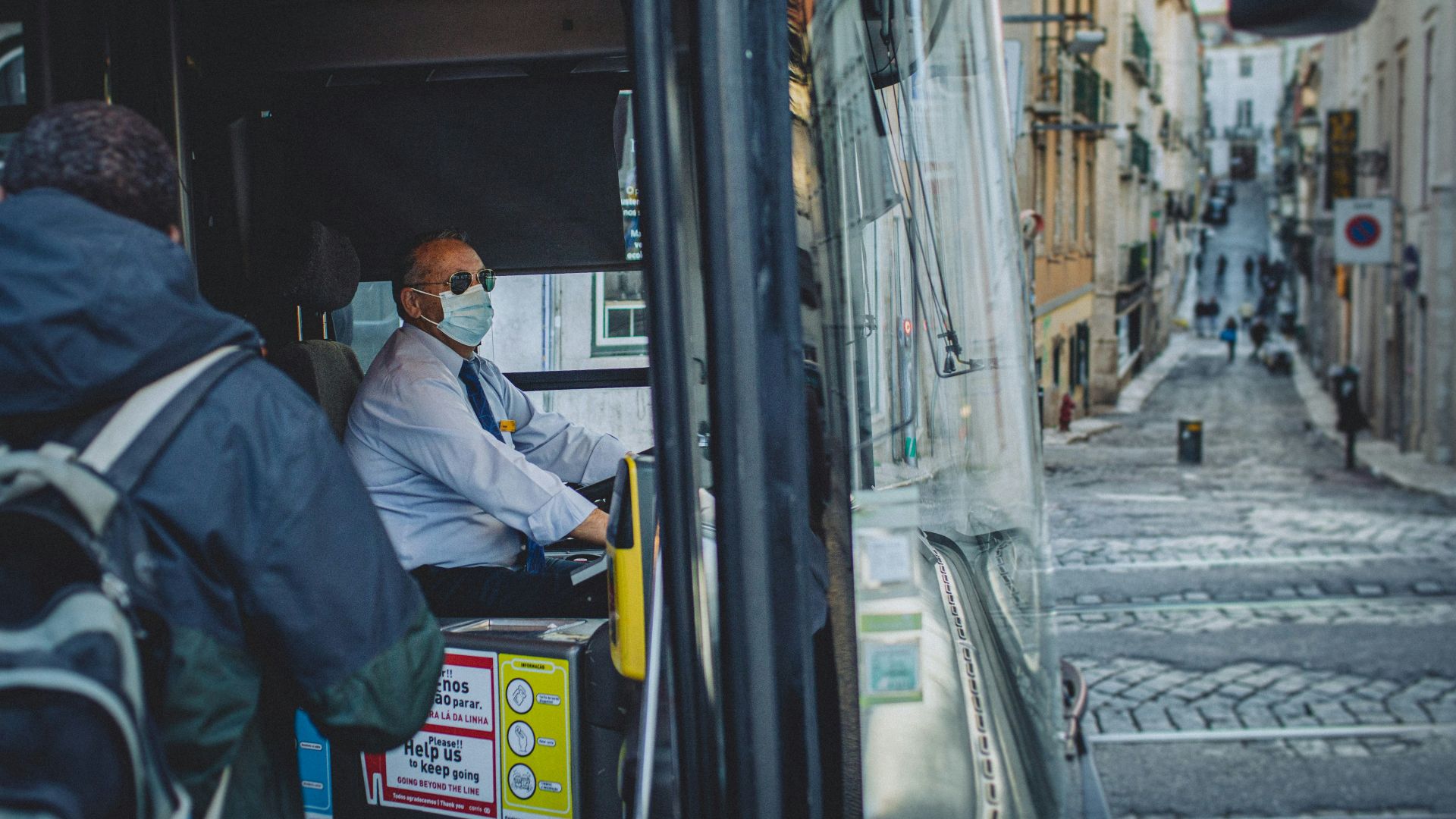 a man wearing a face mask sitting in a bus