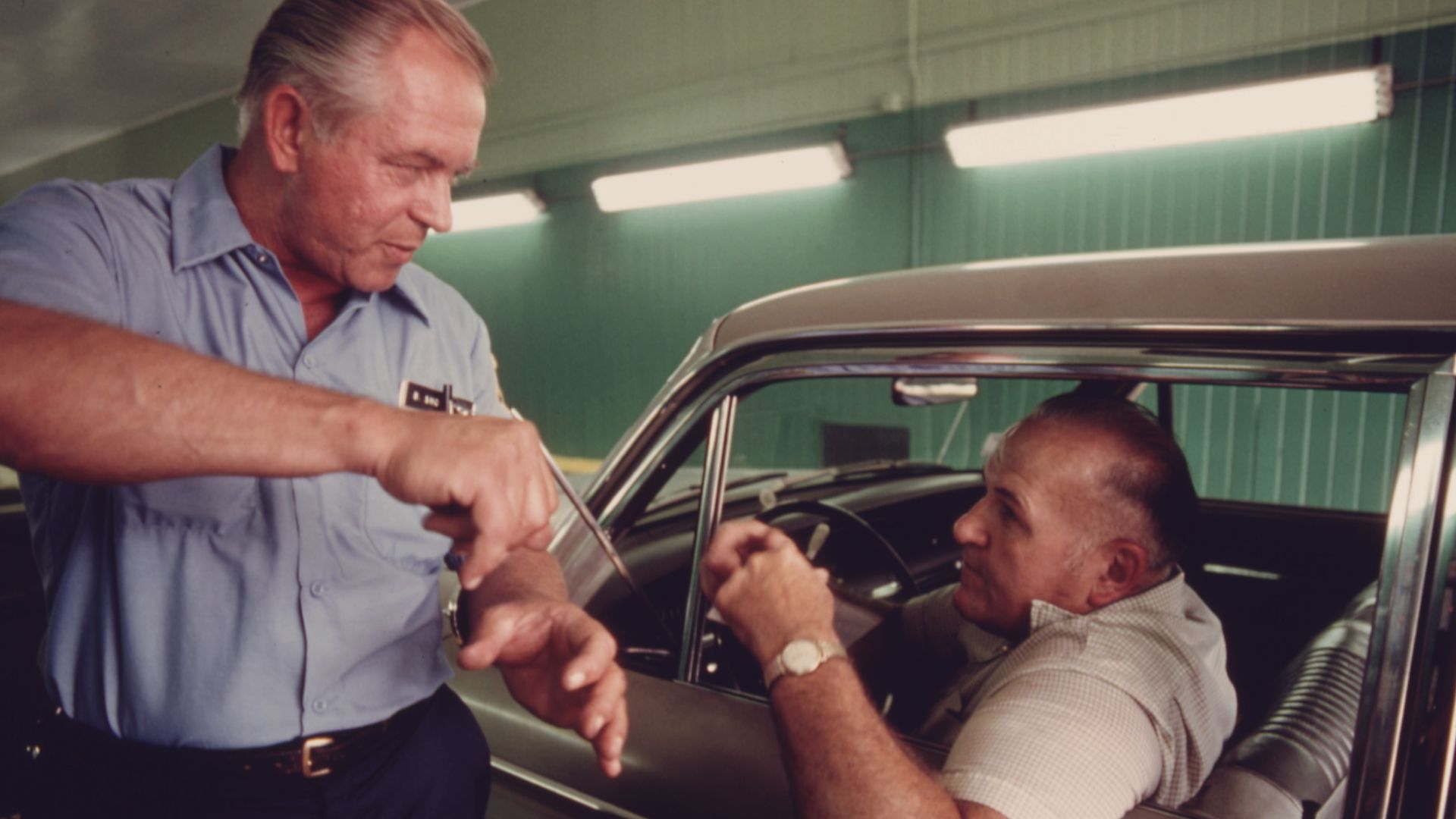 File:PUBLIC WORKS EMPLOYEE AT AN AUTO EMISSION INSPECTION STATION IN NORWOOD, OHIO, GIVES A DRIVER TIPS ON HOW HE CAN... - NARA - 557864.jpg