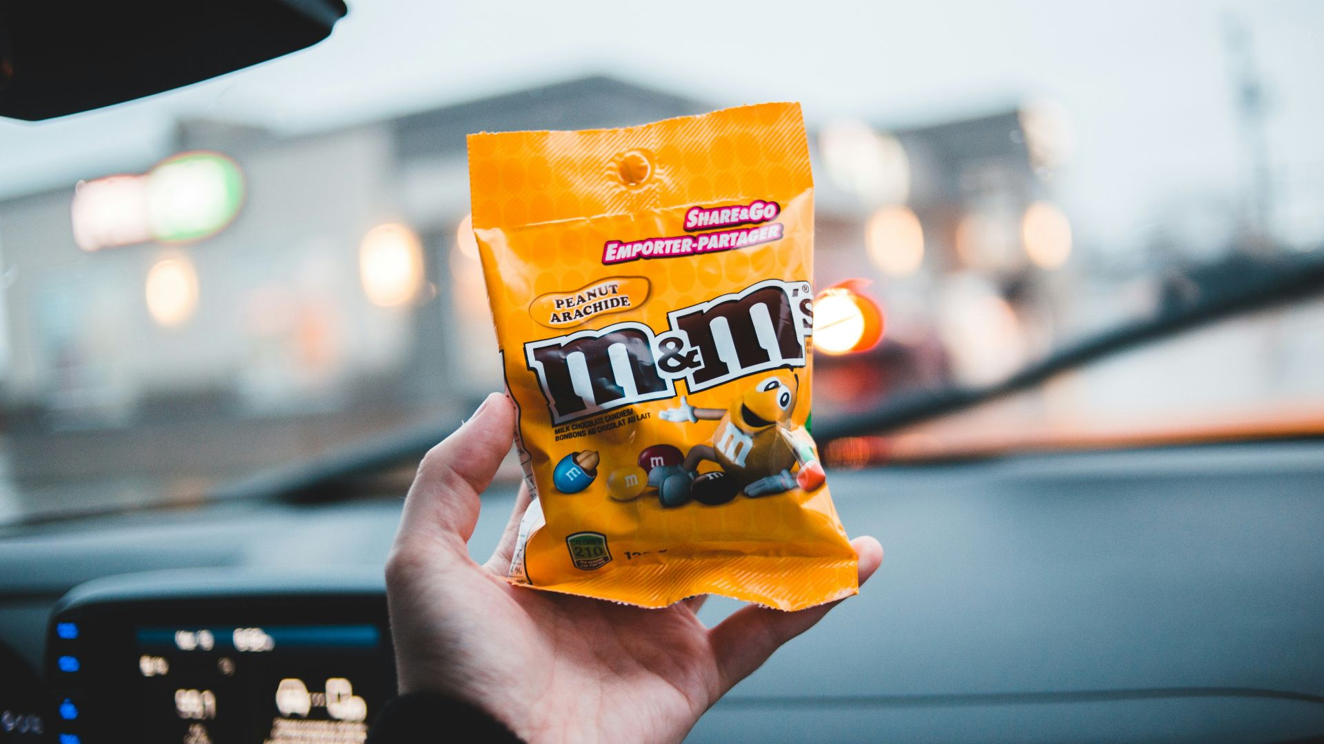 person holding orange and yellow plastic pack