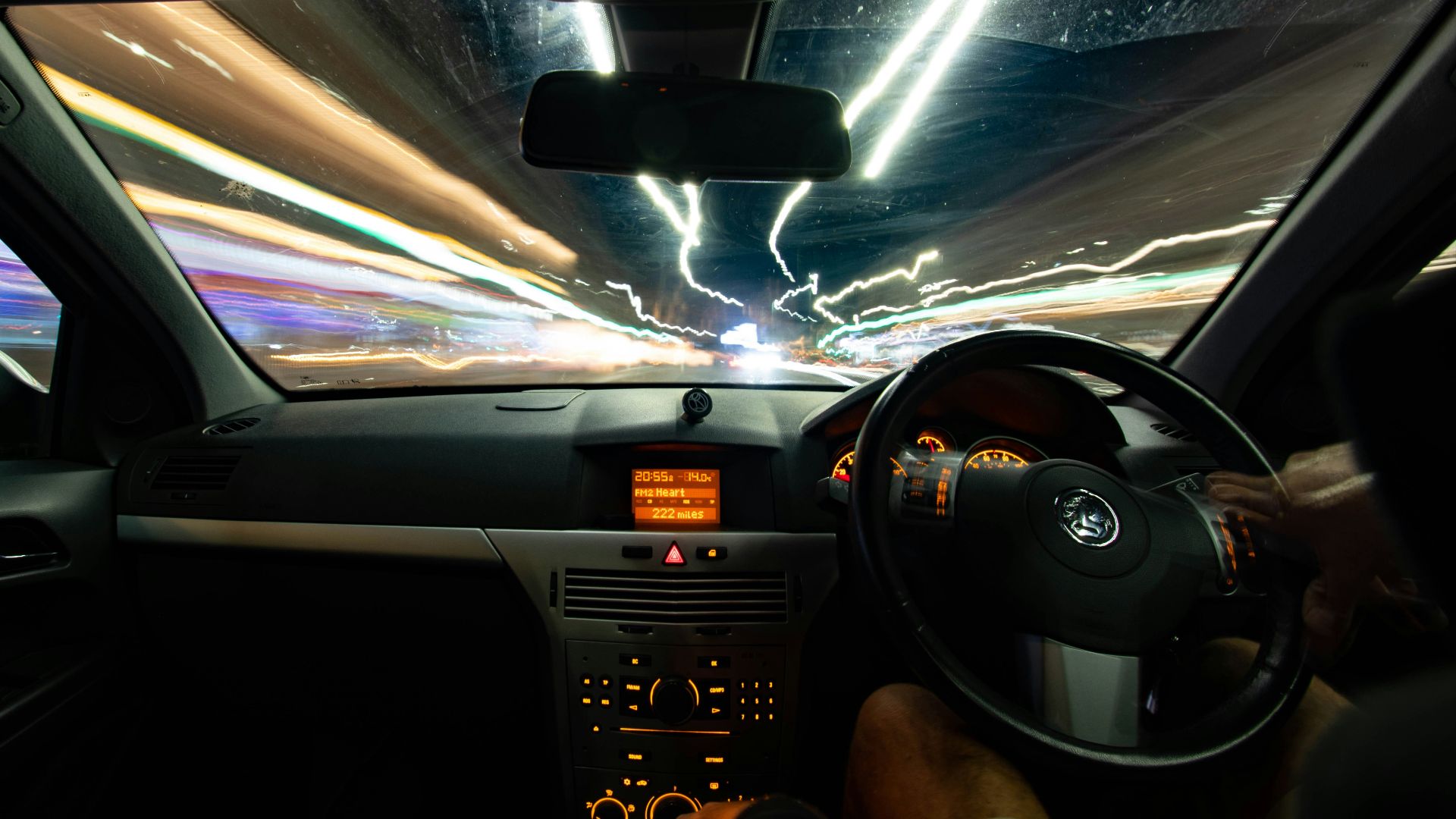 a car driving down a street at night