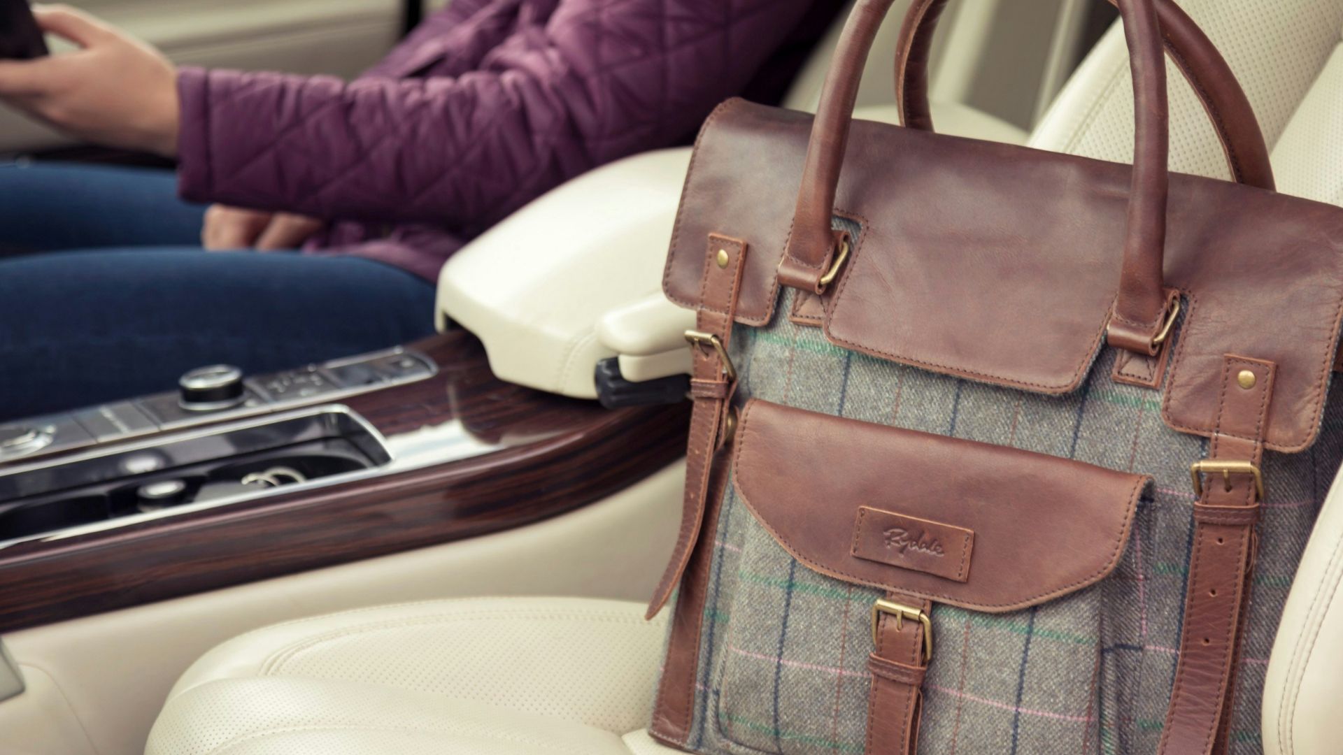 a woman sitting in a car holding a cell phone
