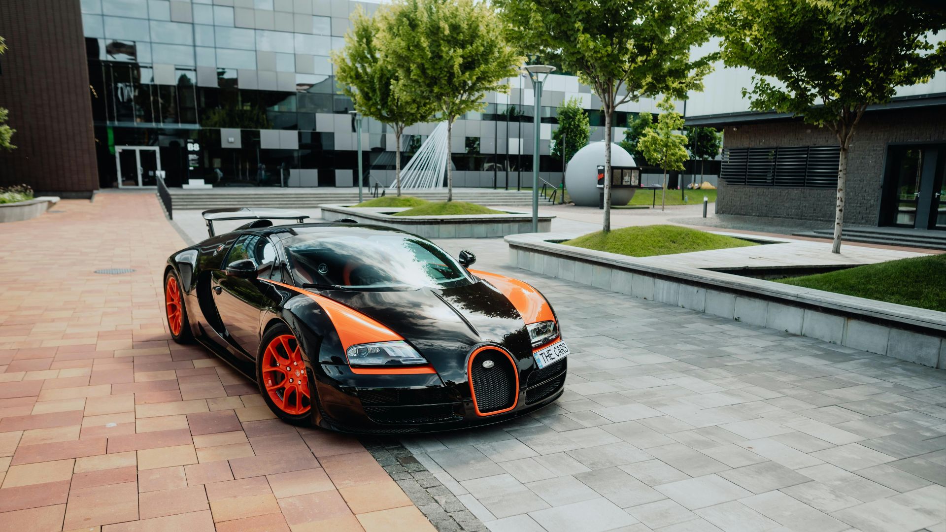 a black and orange bugatti parked in front of a building
